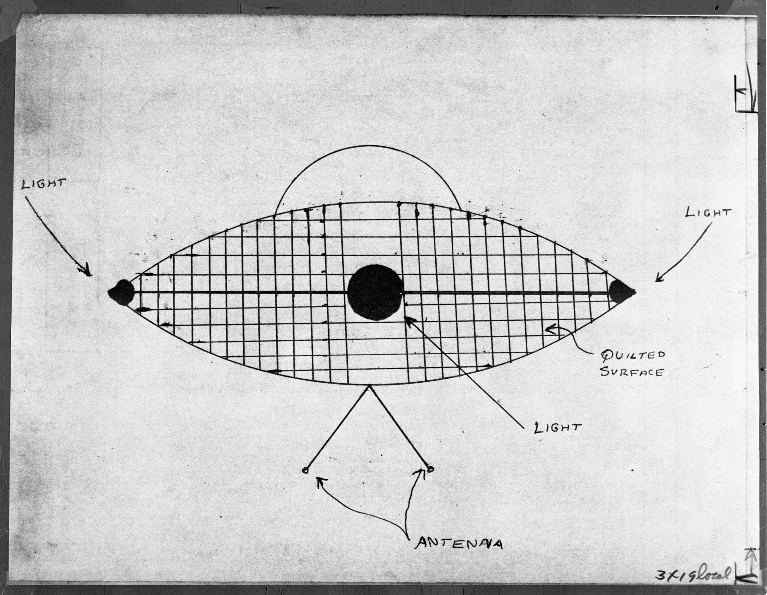 Hand-drawn diagram of an eye-shaped object with a quilted surface, labeled with light sources at both ends, an antenna in the center, and a semi-circular structure at the top.