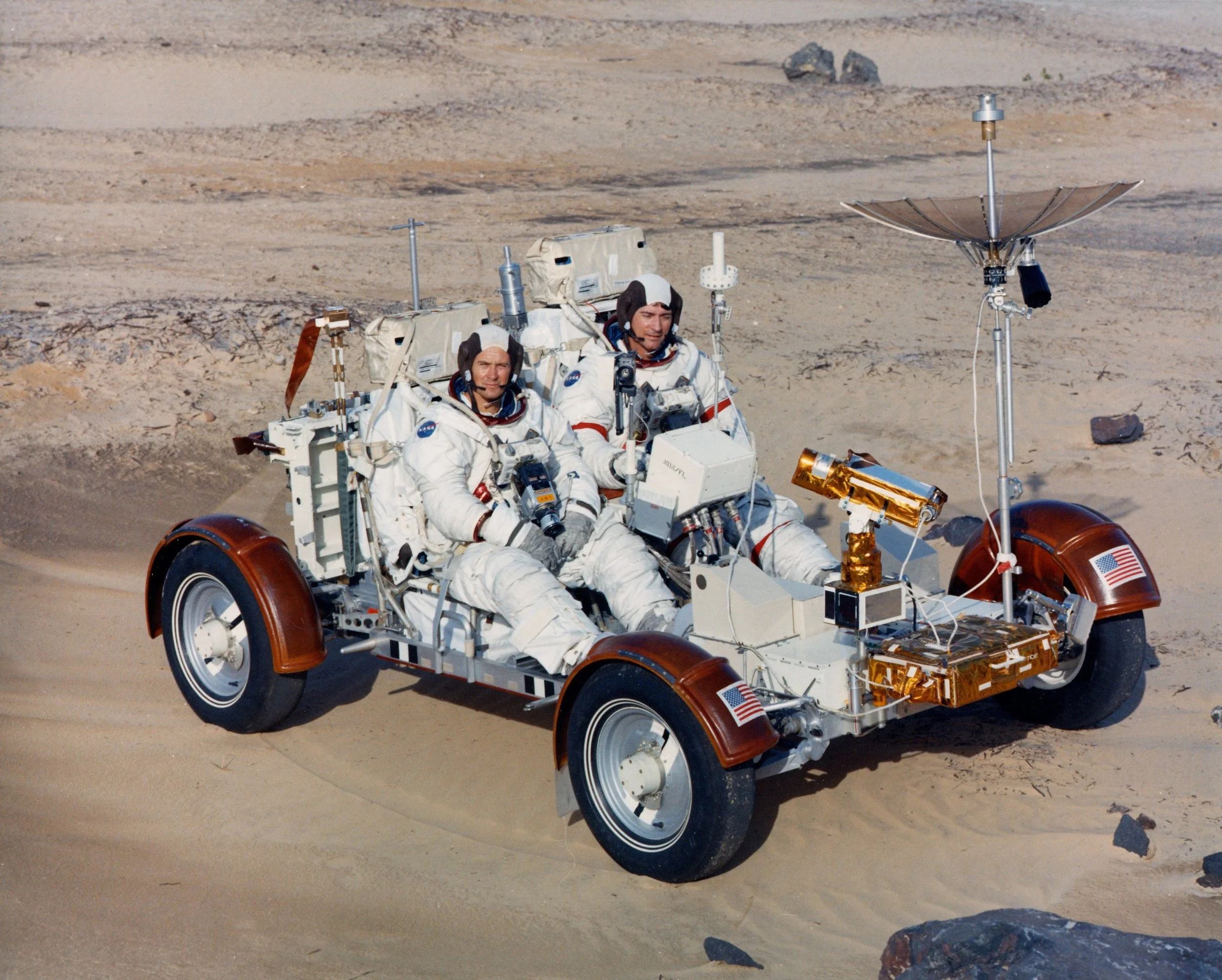 Charlie Duke (left) and Ken Young practice driving the moon buggy on earth