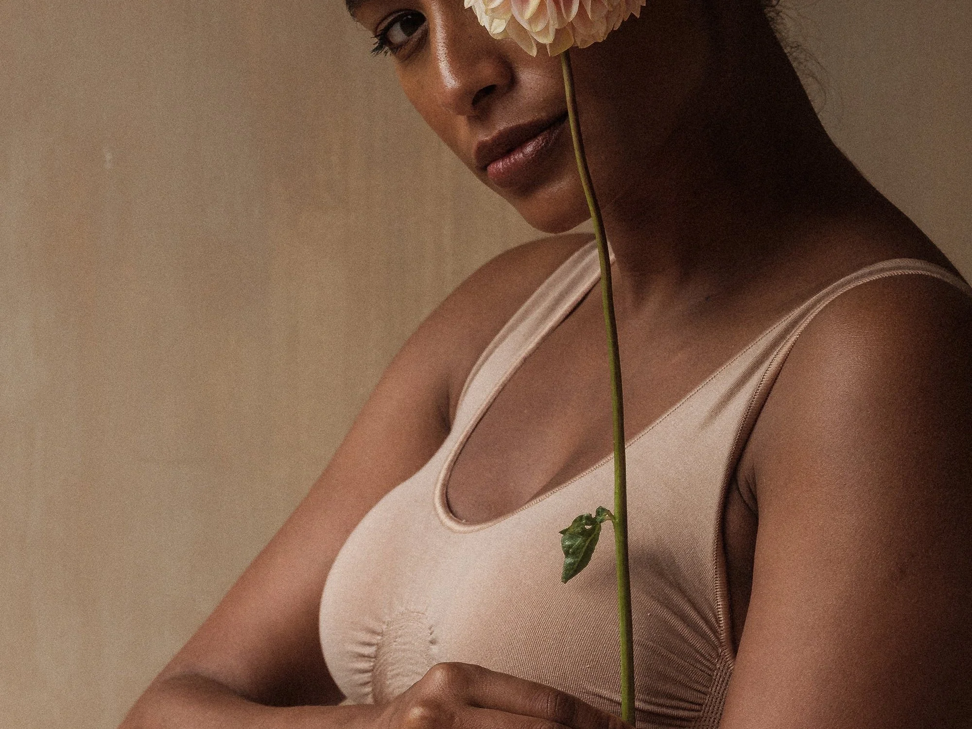 A group of smiling women and men dressed in colorful traditional African clothing, celebrating at an event with balloons in the background.