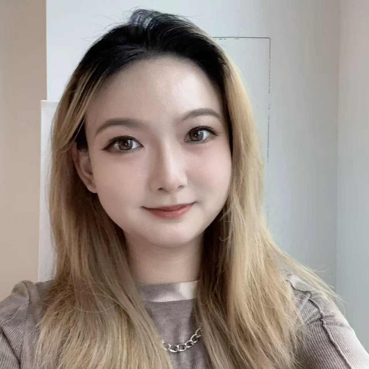 Tianyi Guan- smiling woman with long blonde and black hair of Asian descent. 