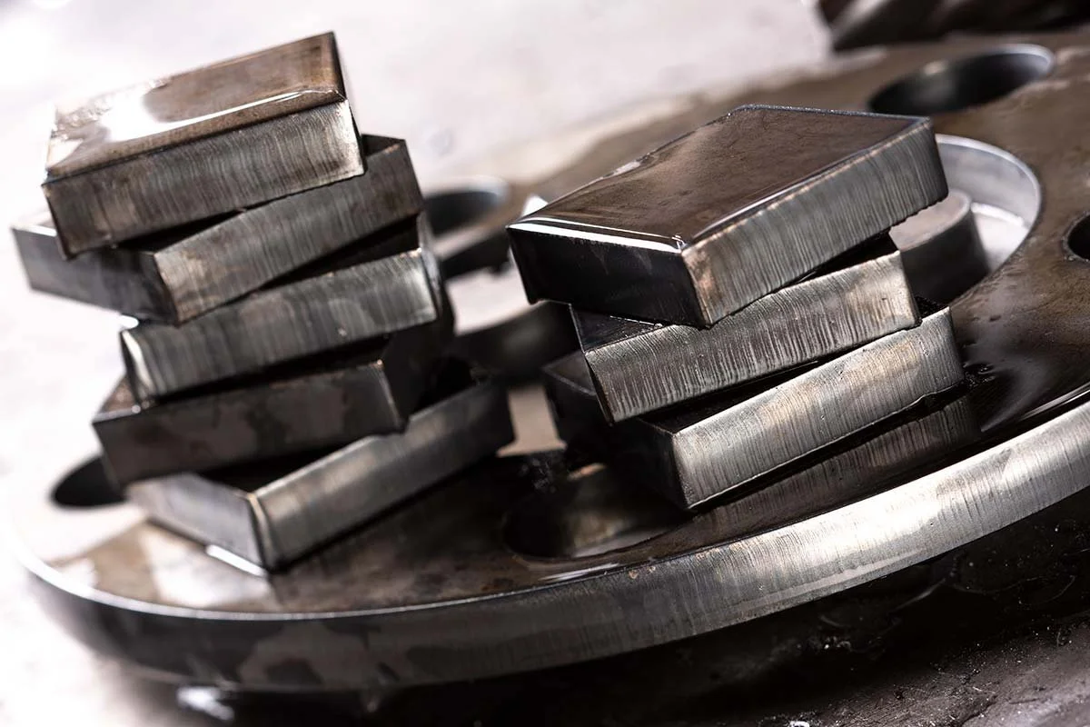 A metal turntable with two stacks of rectangular metal pieces, some stacked unevenly.