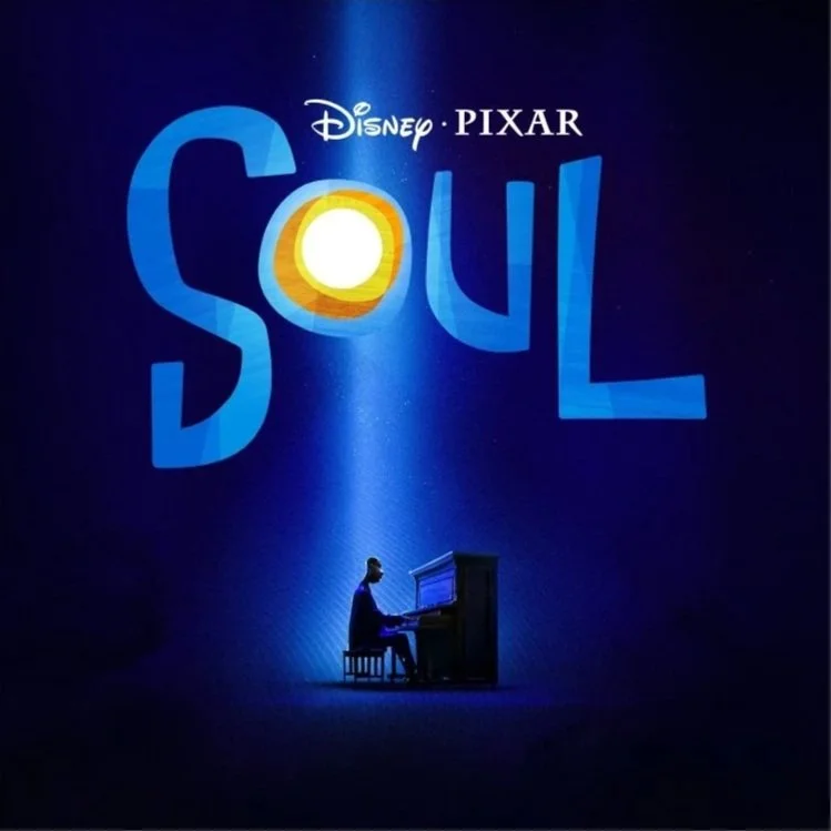 The image shows a promotional poster for Pixar's animated movie "Soul." The background is dark blue with a spotlight shining down, illuminating the Pixar logo, the word "Soul" written in large blue letters with a stylized sun or glowing orb inside the letter "O," and a silhouette of a person playing a piano.