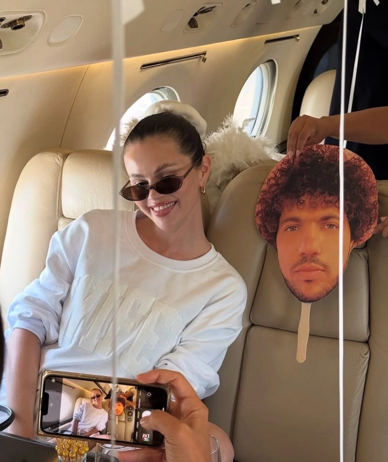 Woman wearing sunglasses posing inside a private jet cabin during a luxury travel experience