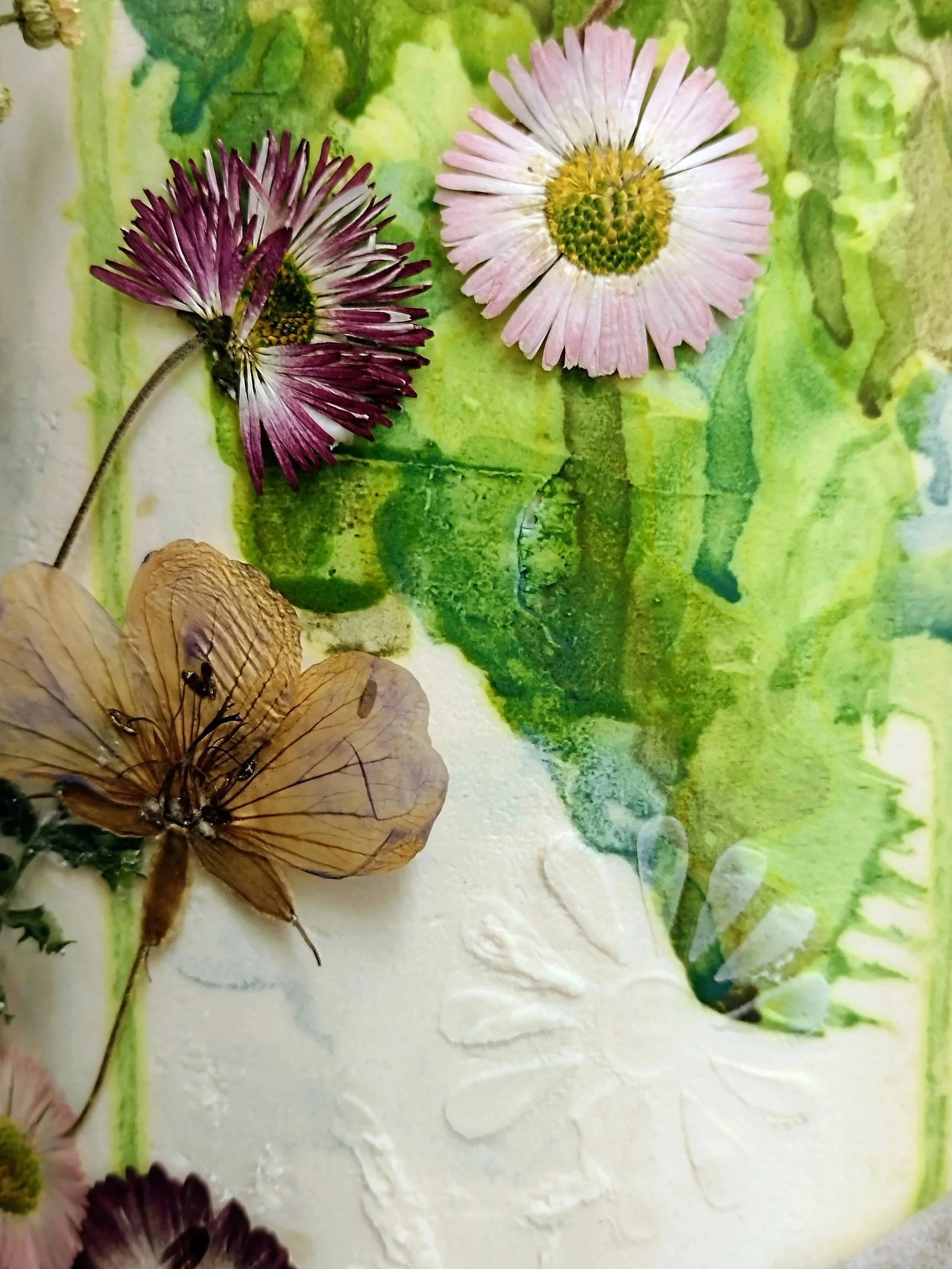 Decorative features of hand pressed edible flowers, cascade on the green painted backdrop and the flower stencil work previously applied to the column of the cake.  Keeping the design natural and in tune with the clients love of flora and fauna. 