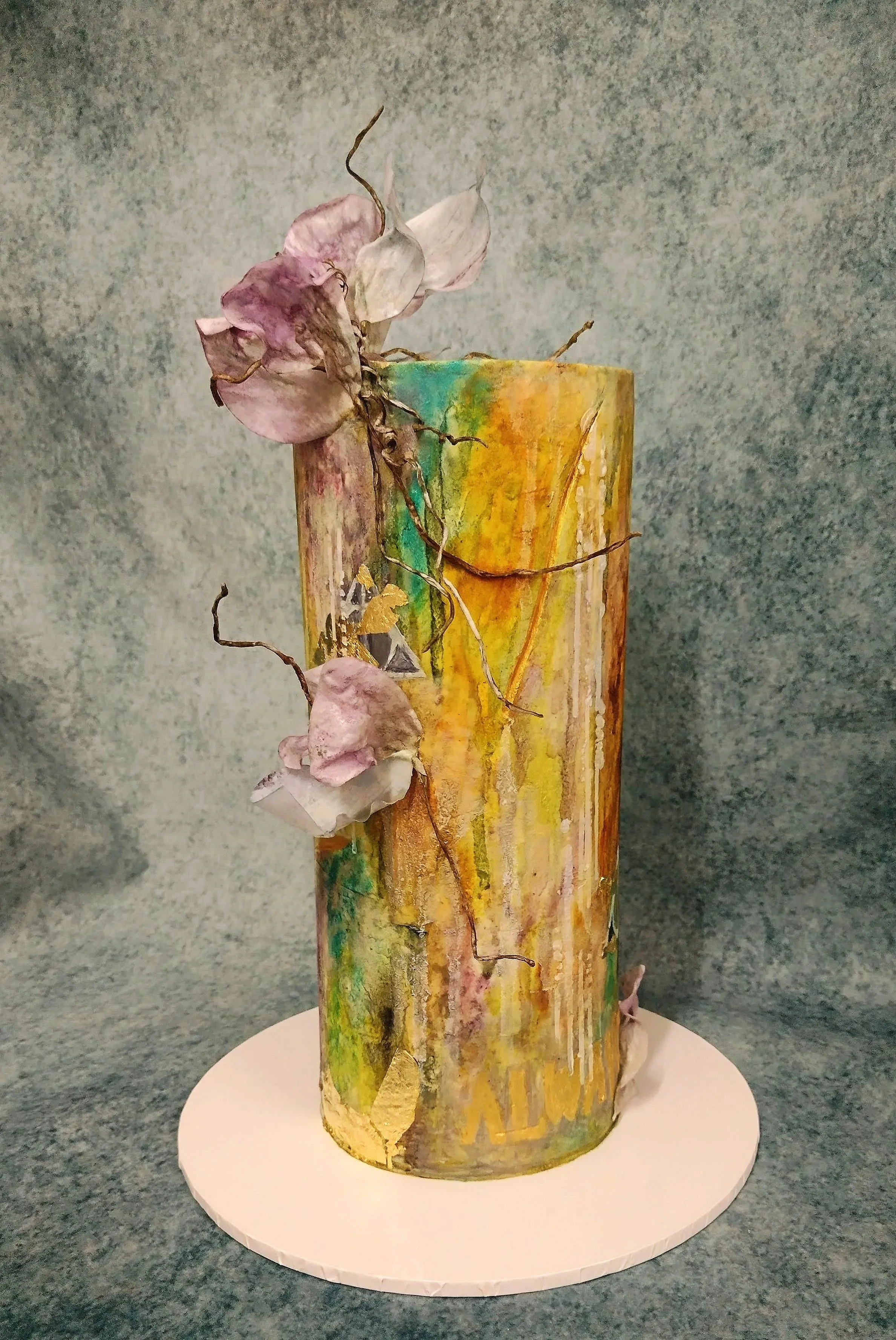 A wedding cake request of abstract water colours painted in natural pigments of gold, green and blue, hand made abstract wafer paper petals and vine branches, a celebratory touch of edible gold leaf and as a person touch from the couple, a discreet n