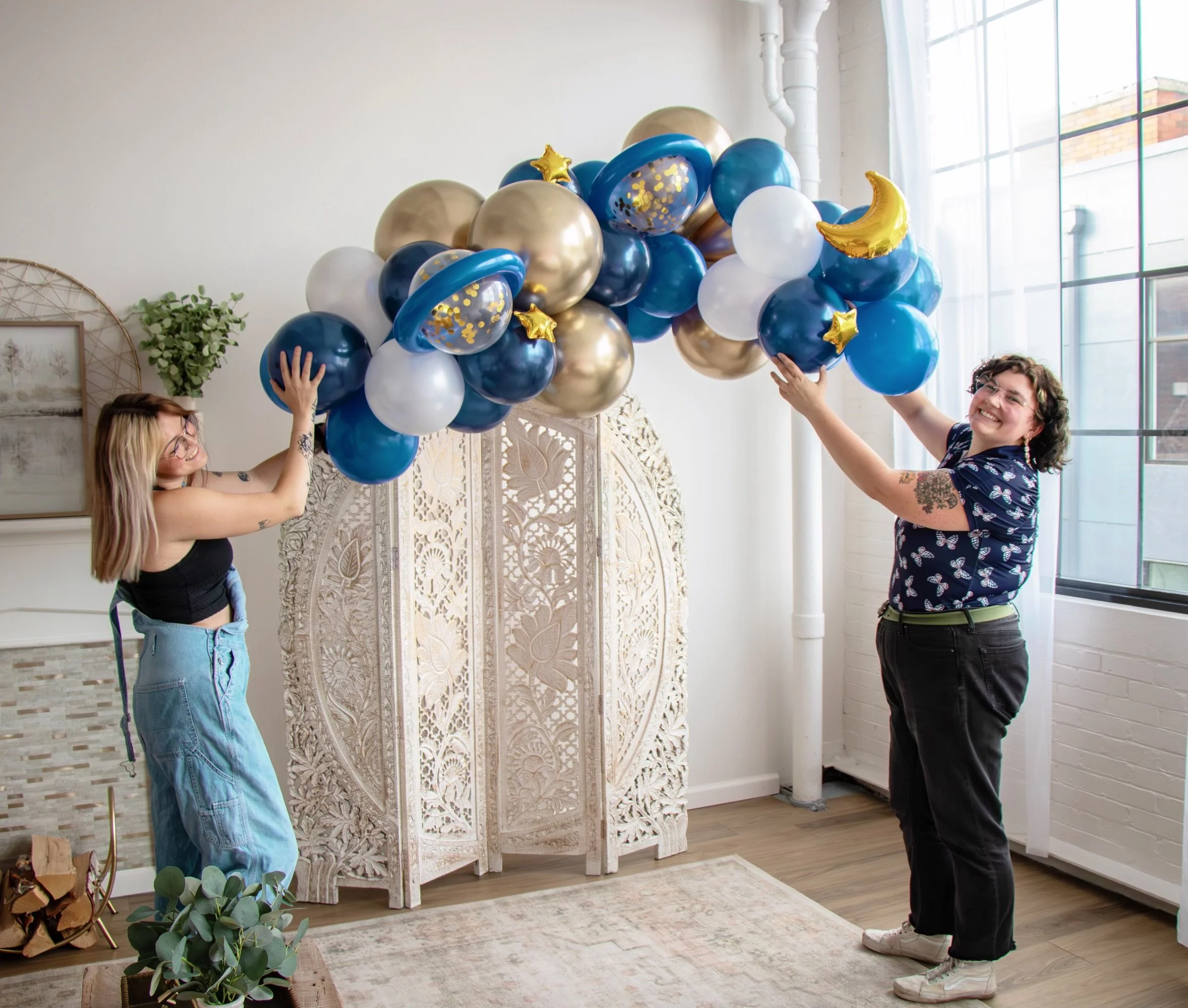 balloon garland balloon arch balloon decor photoshoot for small business promoting their galentines day brunch. decor is space themed and being help by two staff members of the event design company