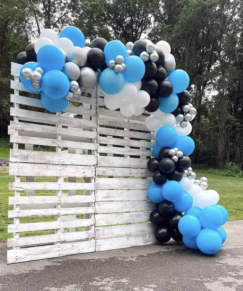 A black, white, blue, and silver balloon garland square backdrop