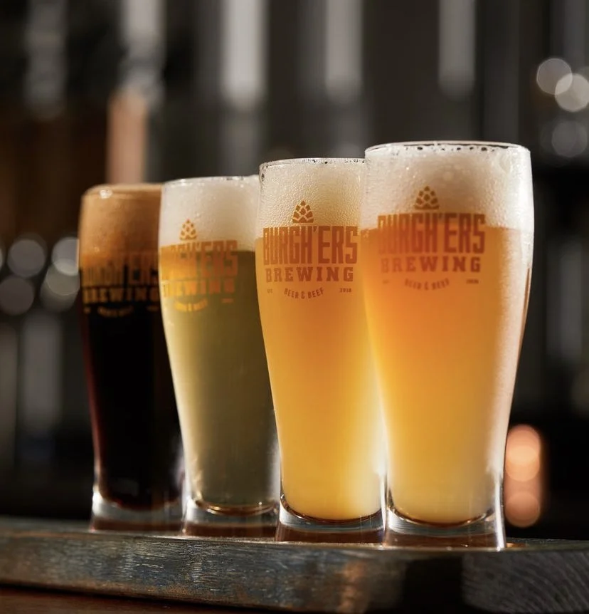 Four beers lined up on a counter at Burgh'ers Brewing in Lawrenceville