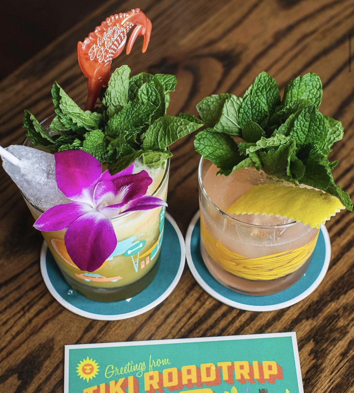 Two tropical cocktails with flowers and mint in them at Hidden Harbor in Pittsburgh
