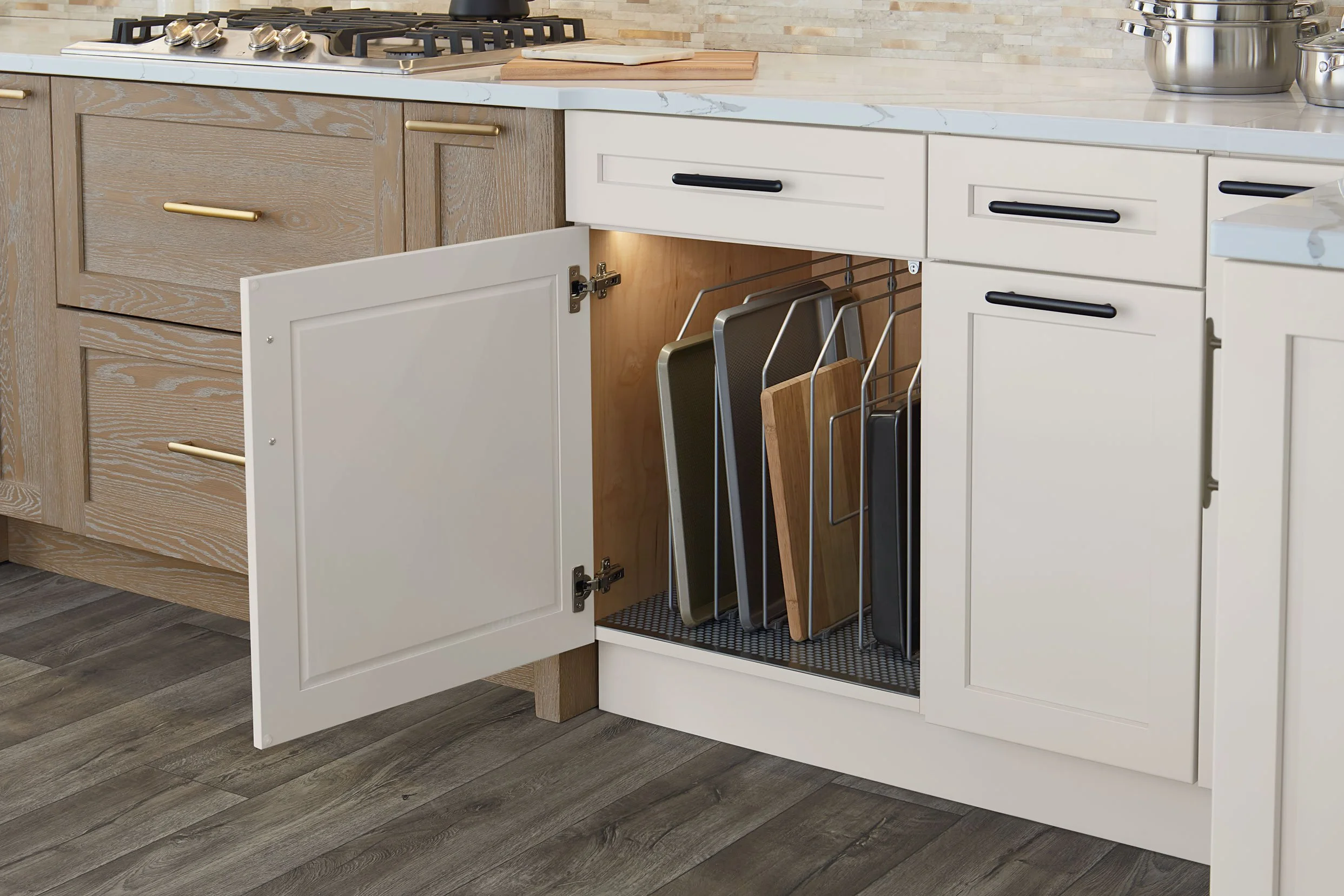 Open kitchen cabinet with multiple cutting boards stored on a rack inside.