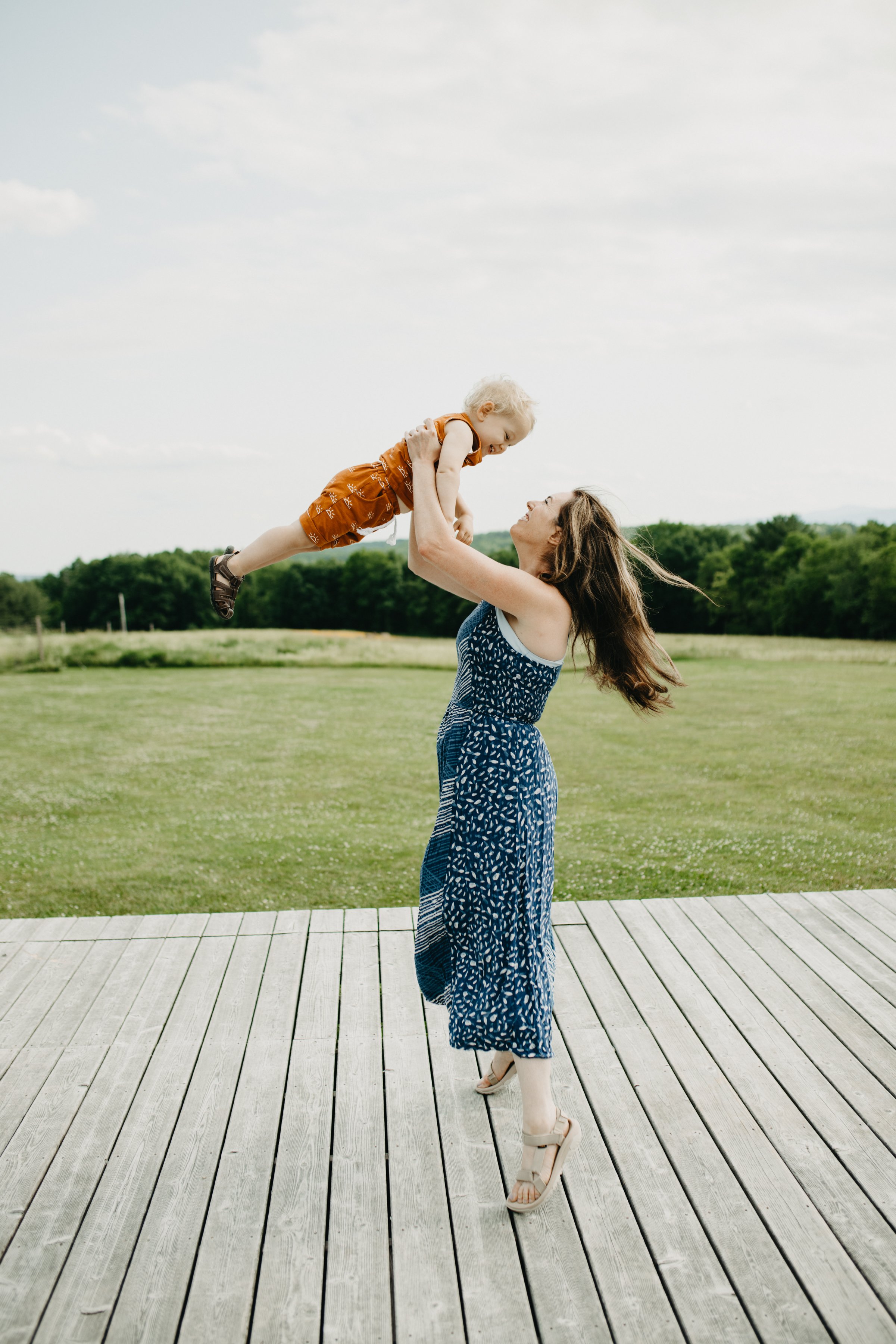 Woman lifting baby in the air outside