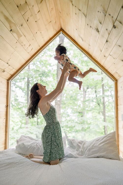 Woman on a bed through a baby in the air
