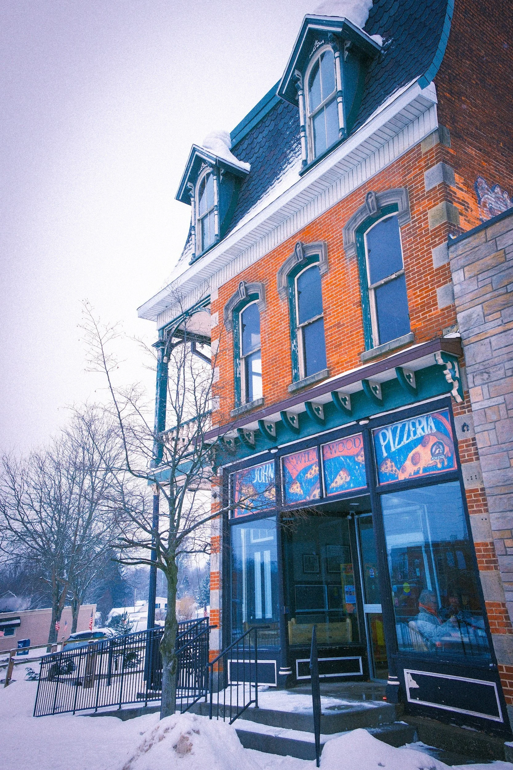 Exterior of Hudson River Lodging with sign and parked cars.