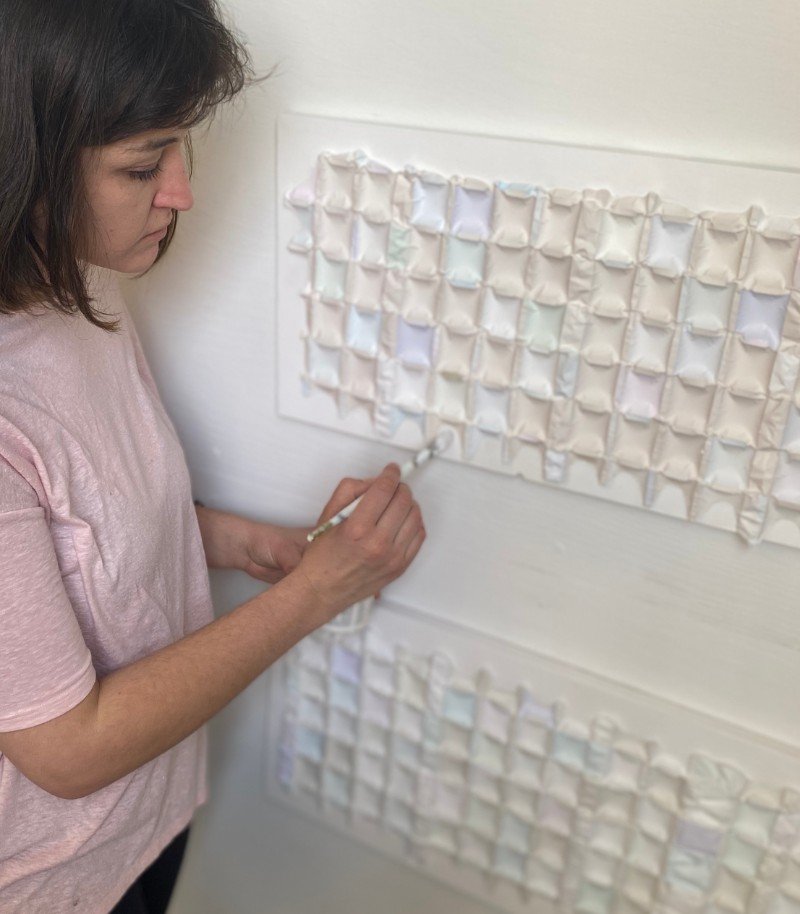 Madeline Walker painting a textured panel.