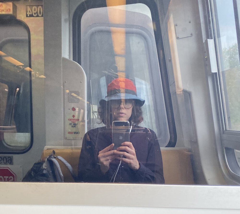 Kate Gorman takes a picture of her reflection while riding the subway