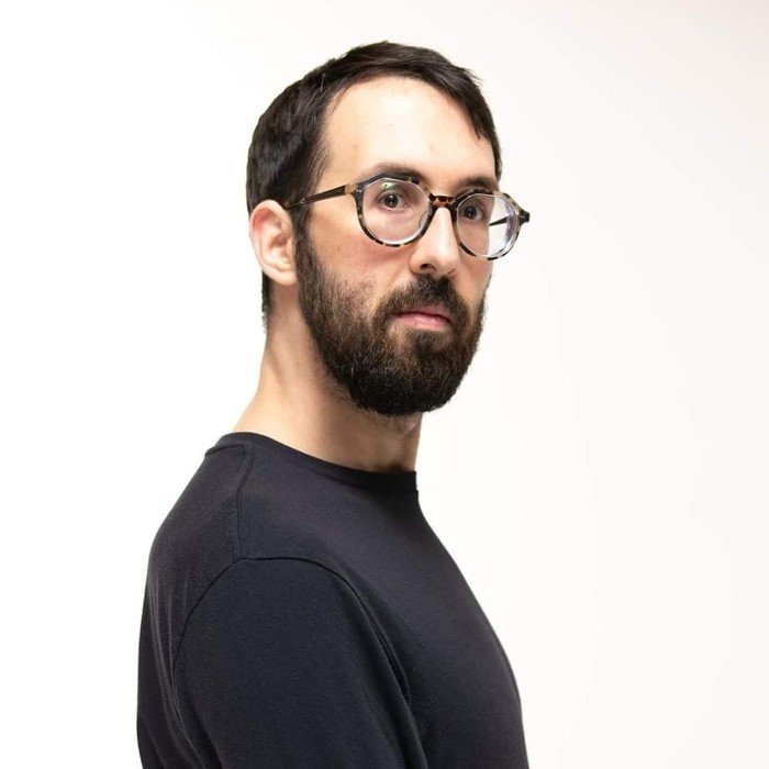 Andrzej Jank in a black shirt against a white background