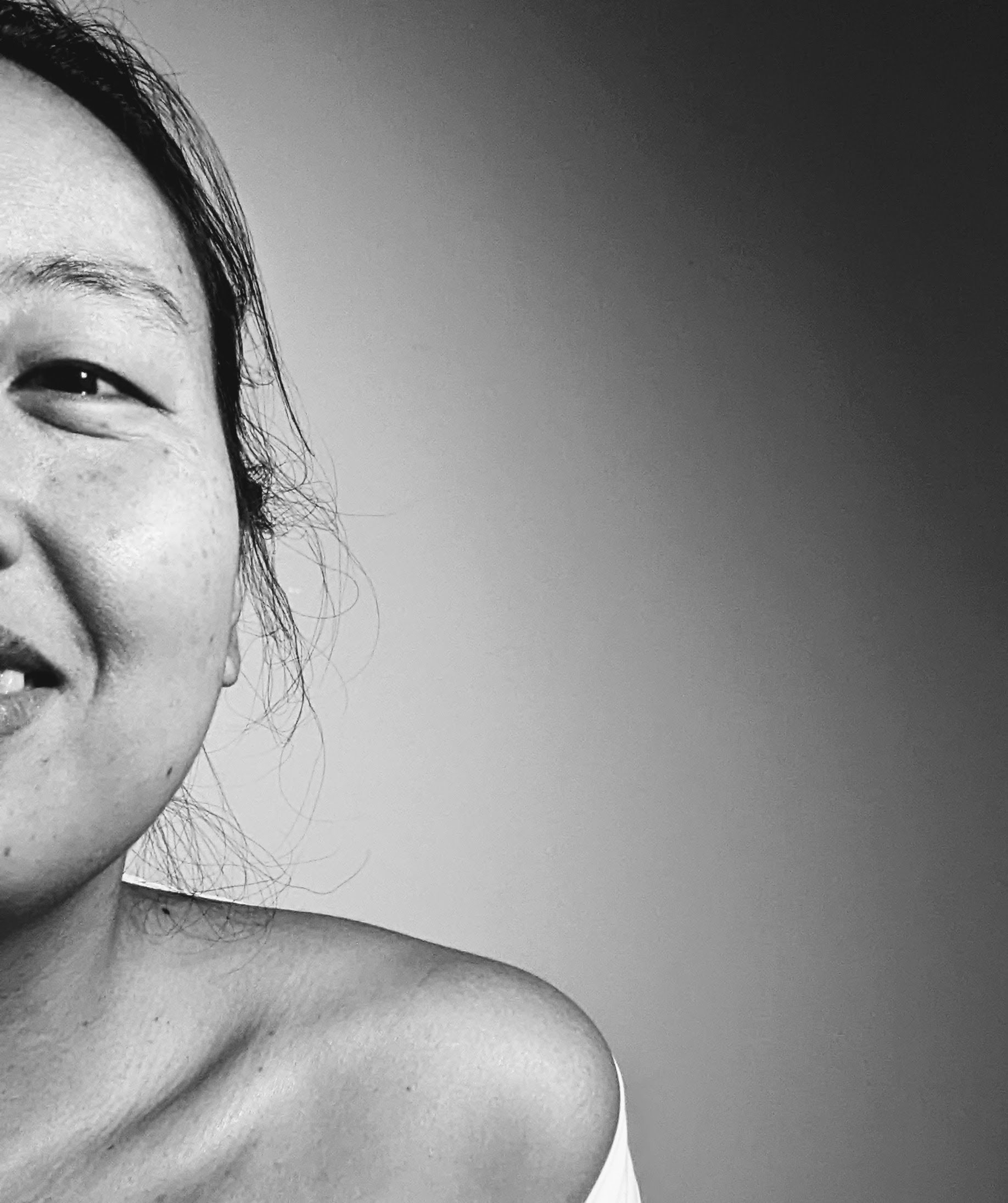 The artist, an Asian-American person, smiling at the camera.