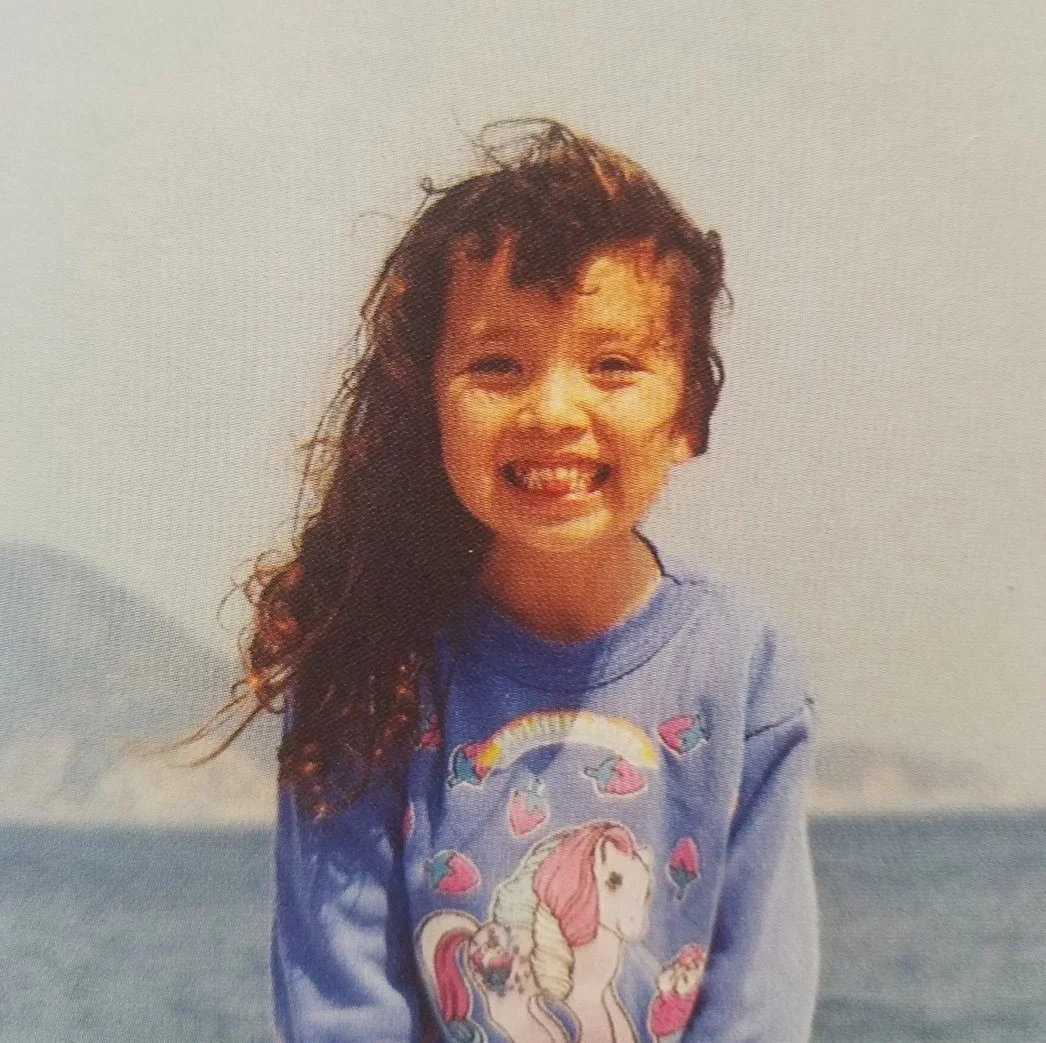 A small child of mixed Japanese and white heritage sticks her tongue out at the viewer.