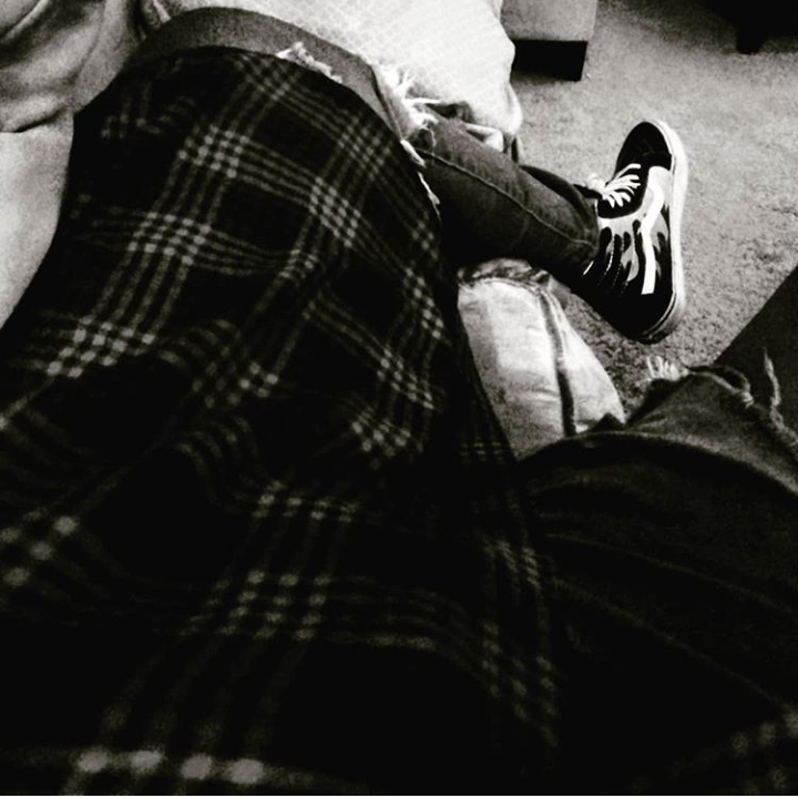 Bria Nelson takes a black and white photo of her own lap and legs while sitting down.
