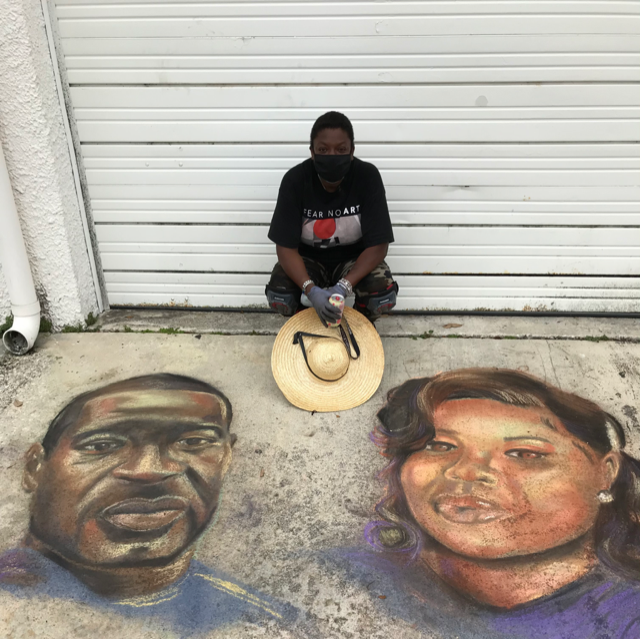 The Black Dalhia posing with her chalk drawings of George Floyd and Beonna Taylor