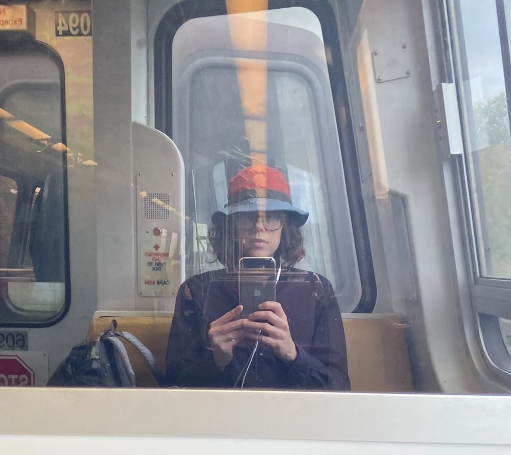 Kate Gorman takes a photo of her own reflection in a subway car window.