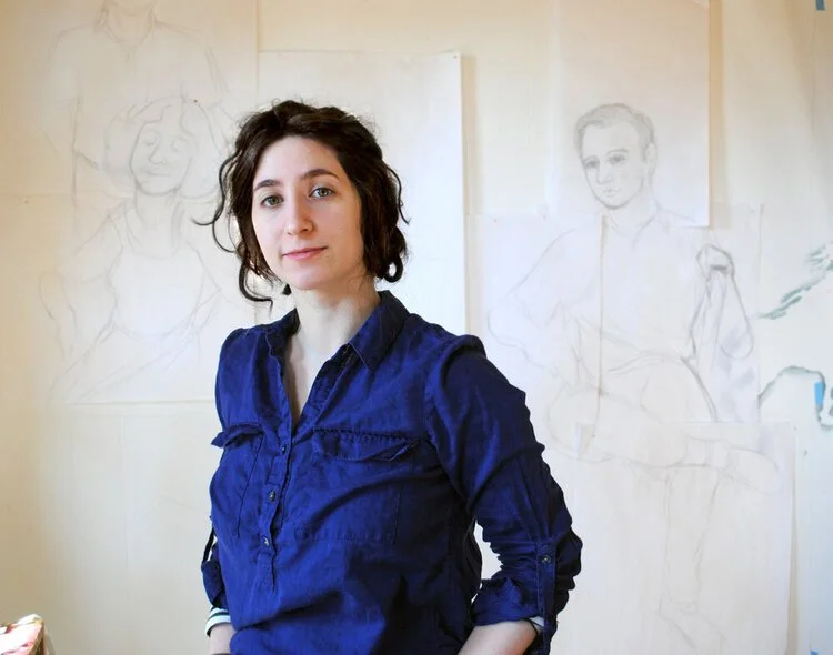 The artist looks into the camera with a small smile.