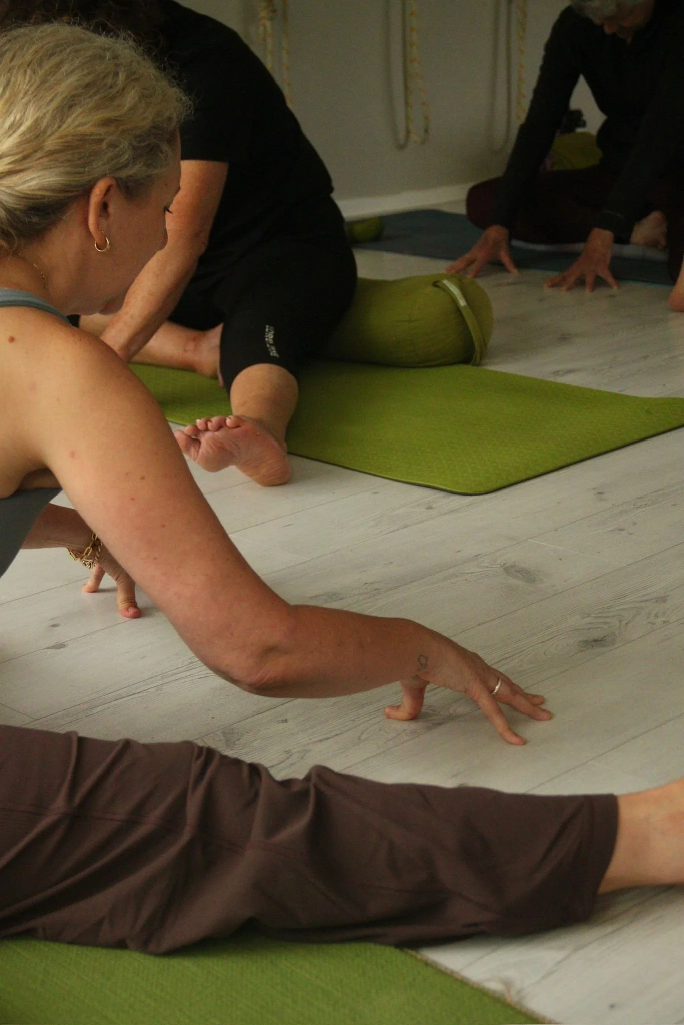 Allyson Lowbridge teaching a yoga class to students practicing yoga.