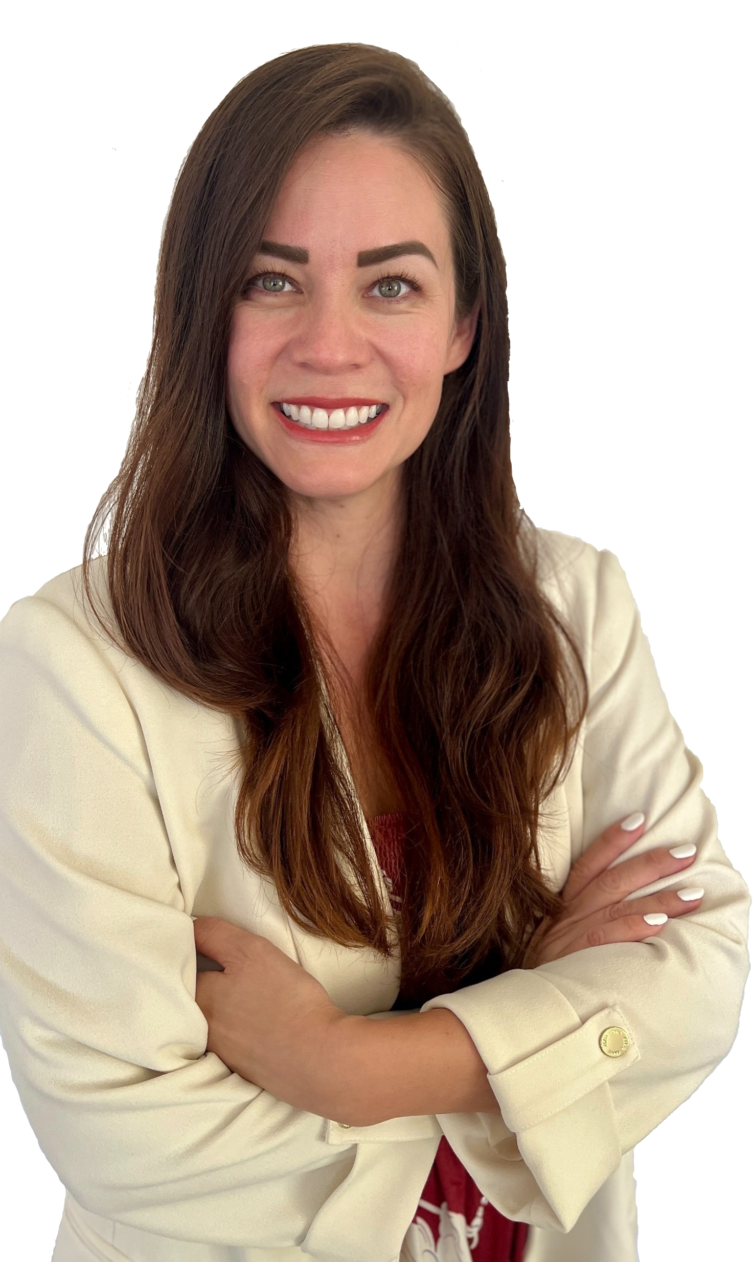 A woman with long brown hair, light skin, and green eyes smiling with white teeth. She is wearing a cream-colored blazer, and her arms are crossed.