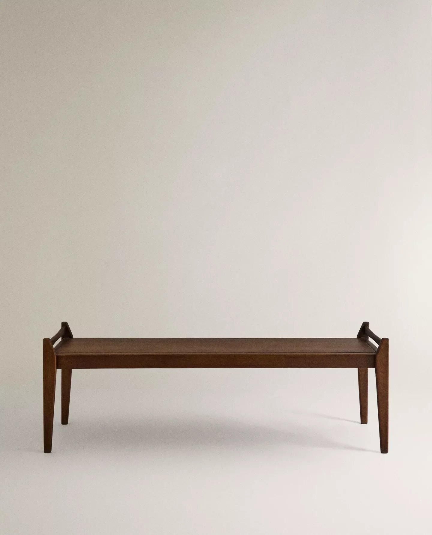 Banco di legno con superficie piana e gambe inclinate.