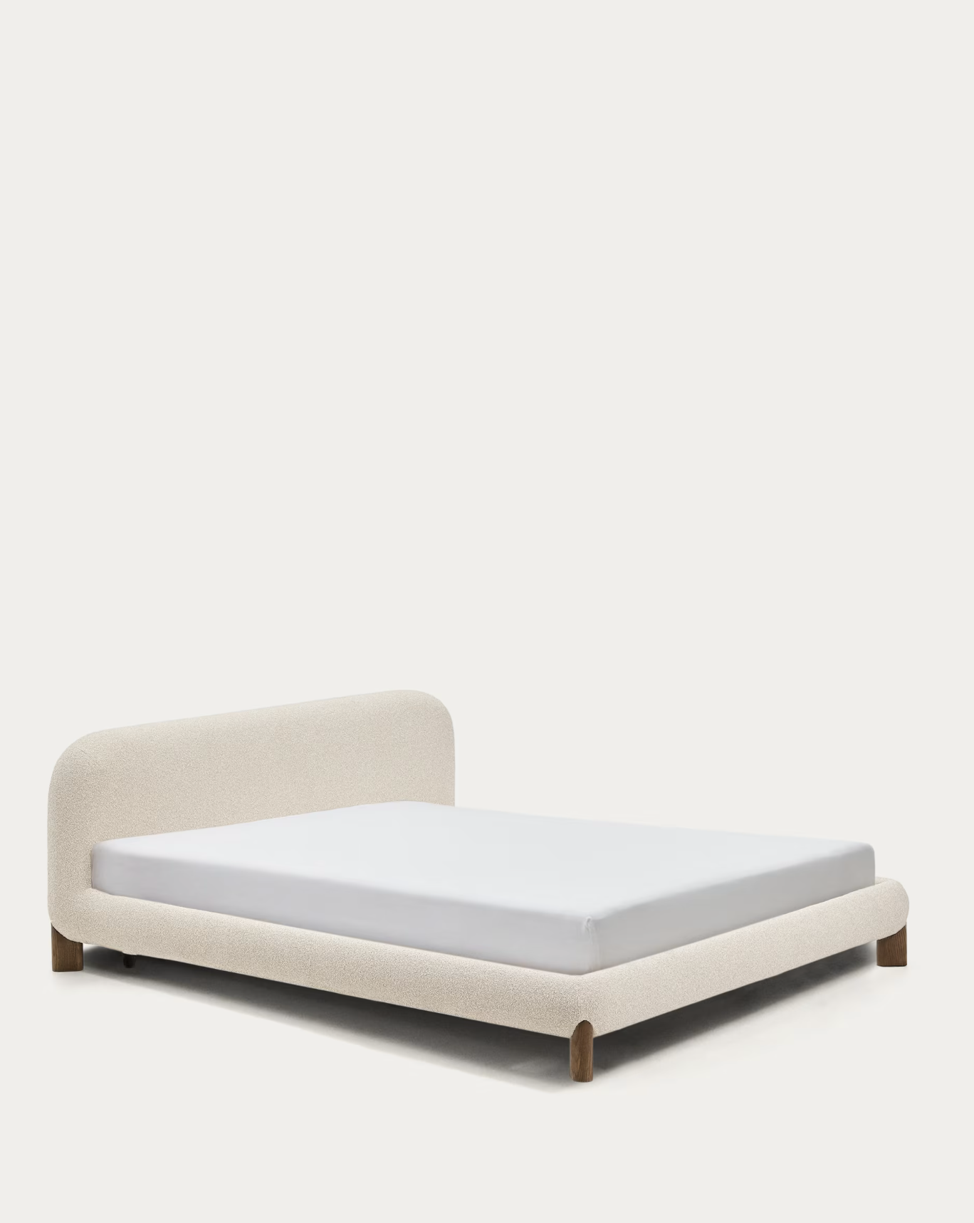 Letto matrimoniale con testiera imbottita e gambe di legno, con materasso bianco, su sfondo bianco.