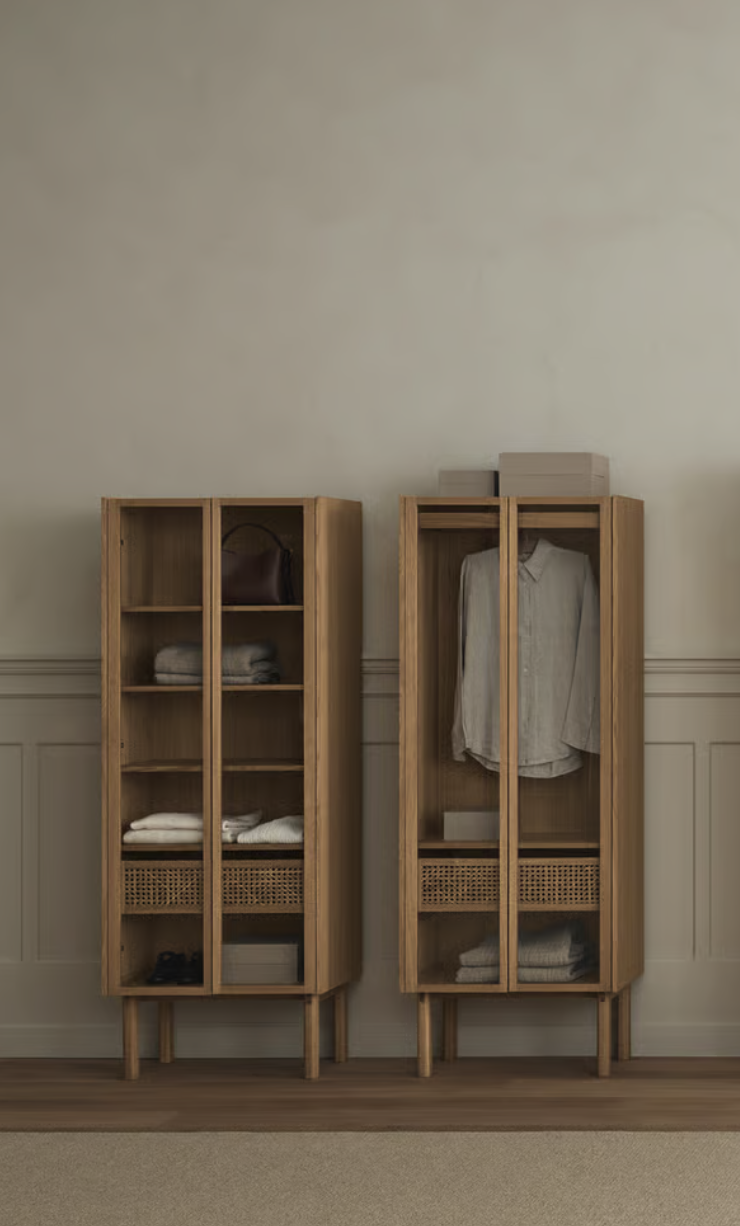 Due armadi di legno con ante in vetro, uno con abbigliamento appeso e l'altro con vestiti piegati, in una stanza con pannelli di carta in basso e pareti beige.