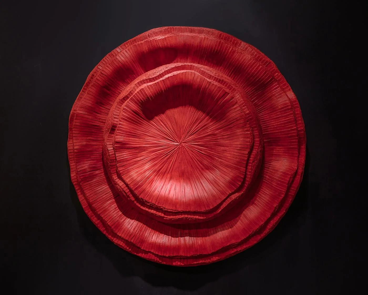 Bright red round layered wall sculpture with radiating pleats, by Michel Mullèr
