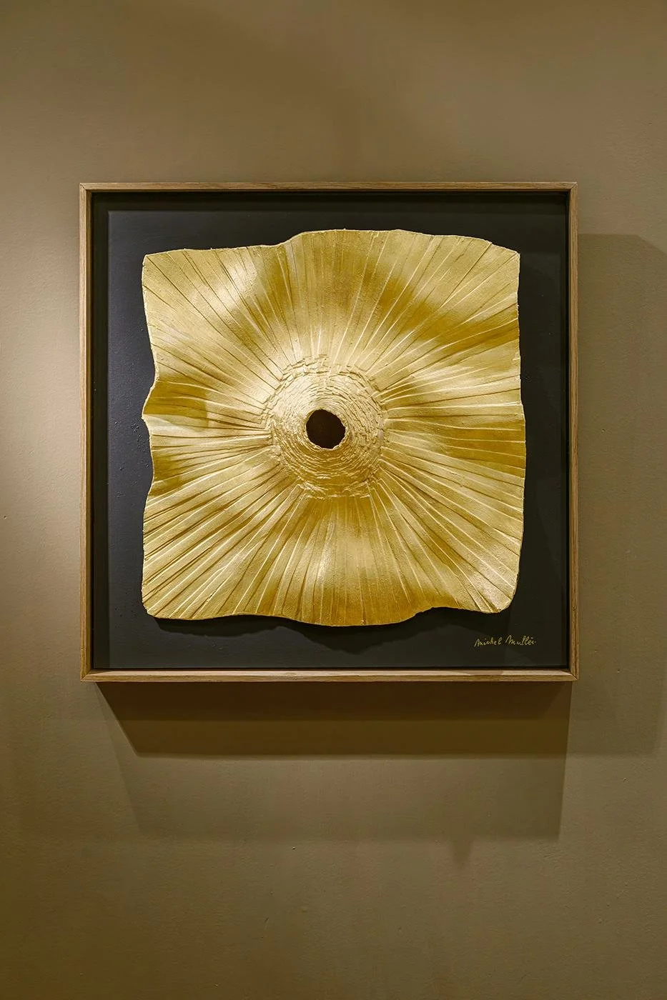 Golden radiating relief with a dark centre in an oak frame, by Michel Mullèr