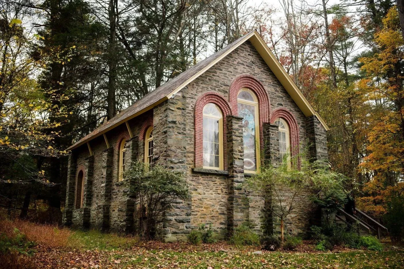 Parkside Chapel in Henryville, PA, surrounded by autumn leaves before an intimate queer Korean wedding ceremony