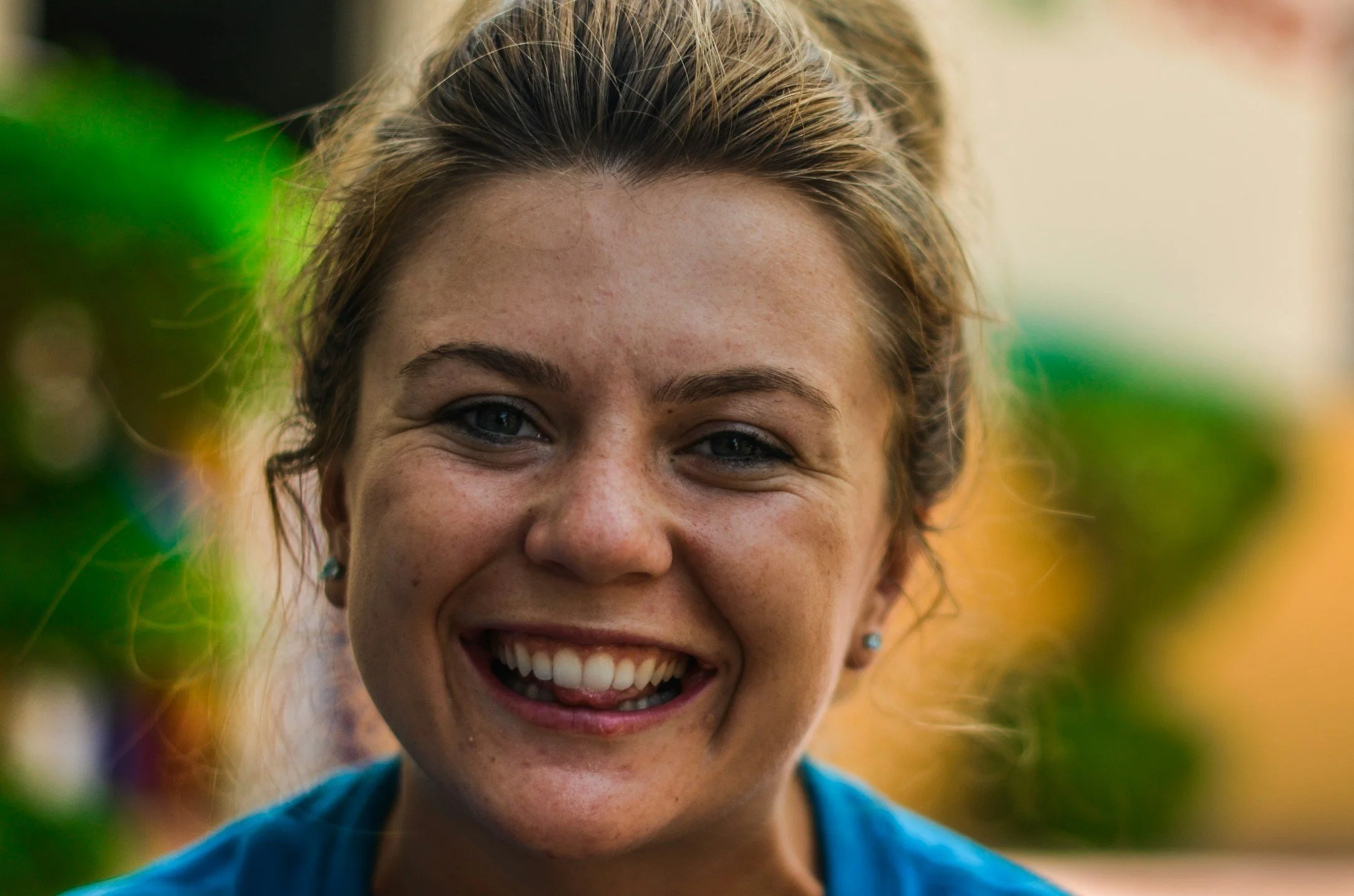 woman with a bun smiling into the camera