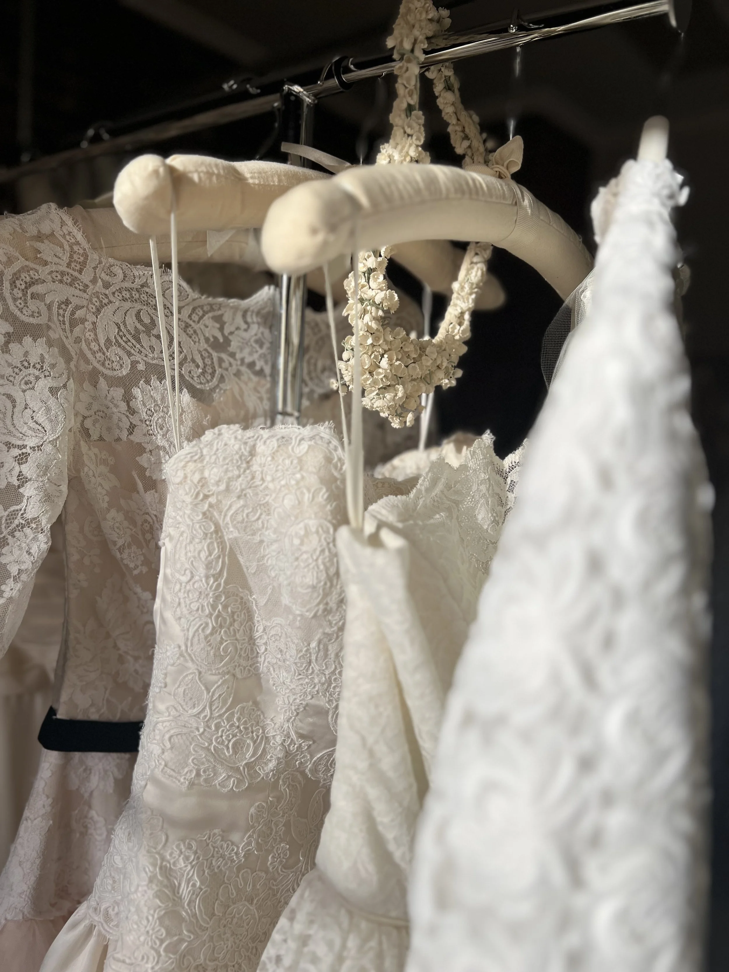 Rack of wedding gowns with vintage bridal look at Maybelle Atelier.