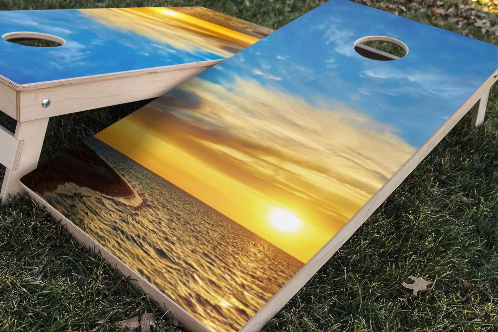Cornhole board wrap sticker decal set showing a sunrise through clouds over a beach and ocean water