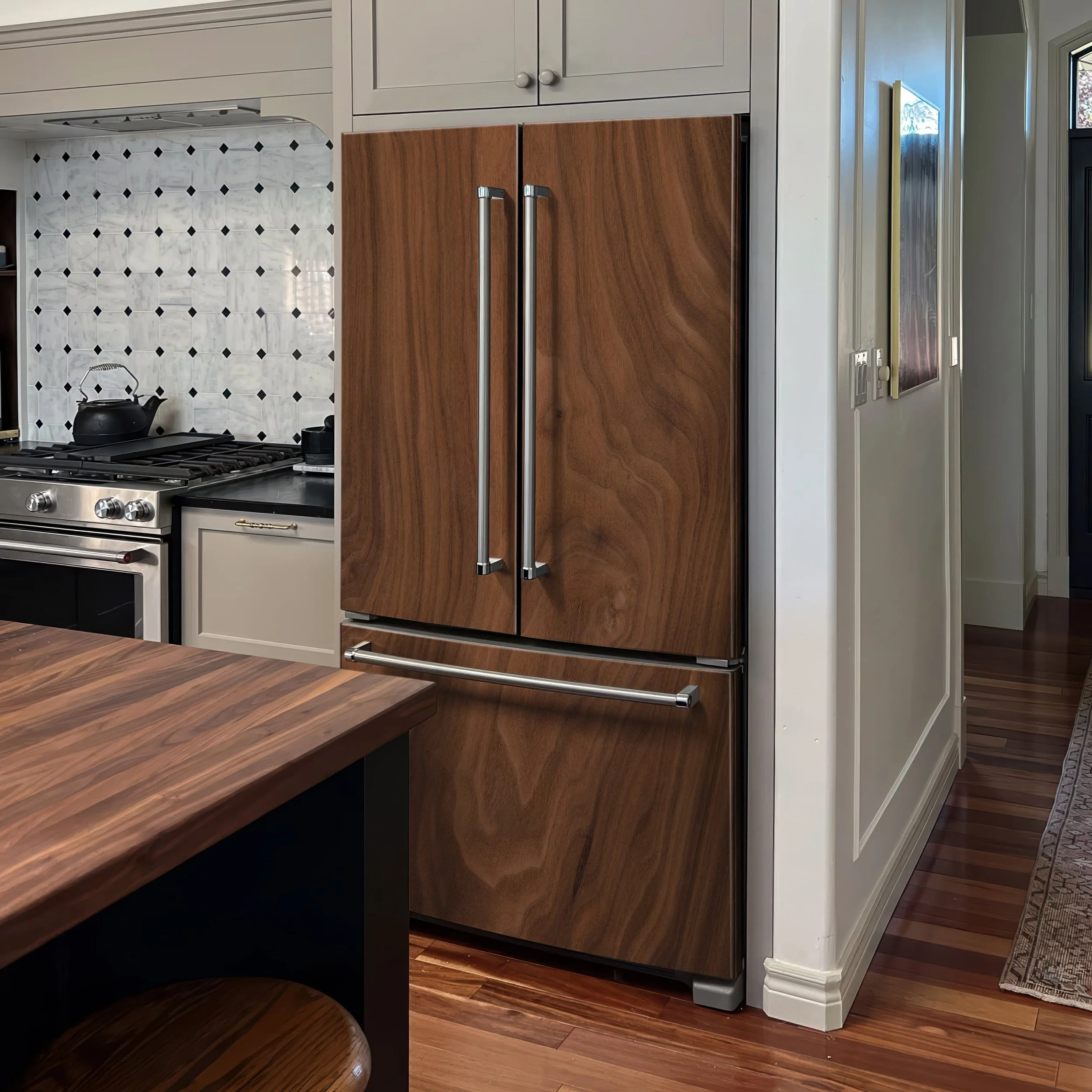 A side-by-side style refrigerator in a modern kitchen shown wrapped with an oil-finish colored wood slab custom-printed vinyl skin.