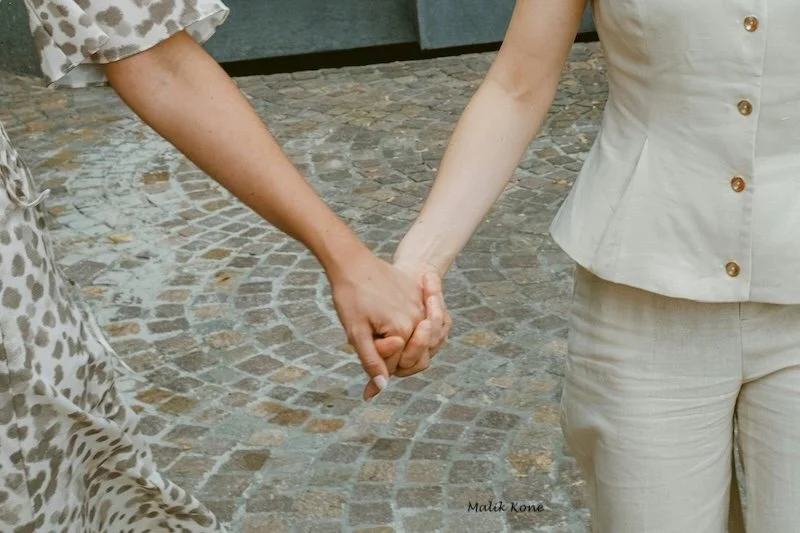 Two women holding hands.