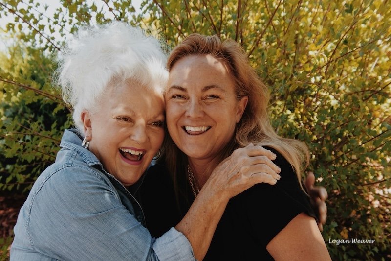 Two women hugging and laughing.