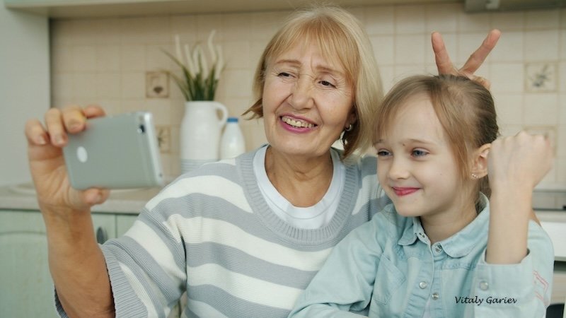 A grandmother and a grand daughter taking a selfie.