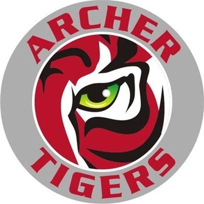 Logo of the Archer Tigers featuring a stylized tiger face with green eye, red, black, and white accents, and text "Archer Tigers" in red around the image.