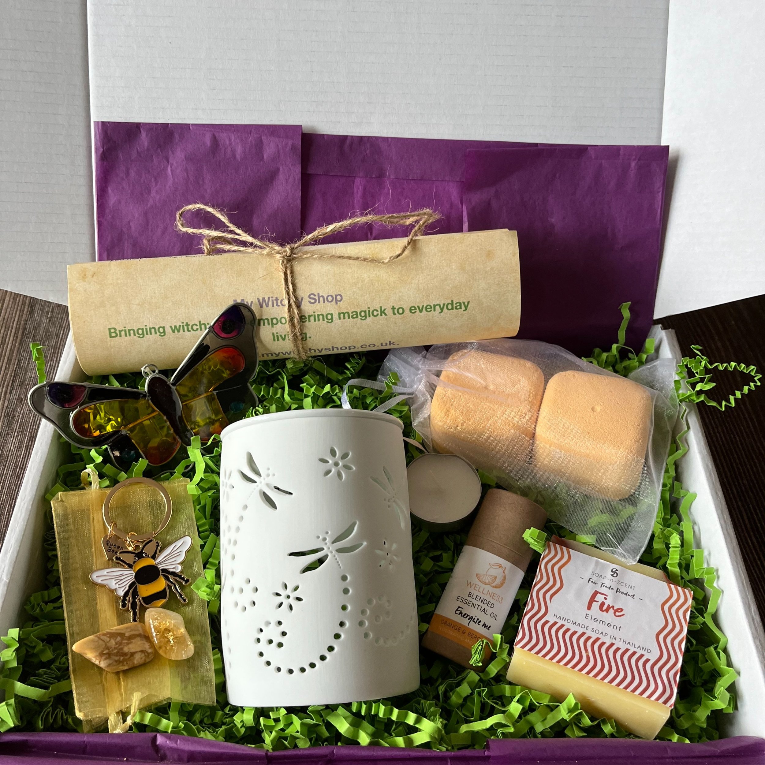 Gift box with energising items. oil burner with energising oil. energising shower steamers. fire element soap. bee key ring, butterfly suncatcher and energising crystals.