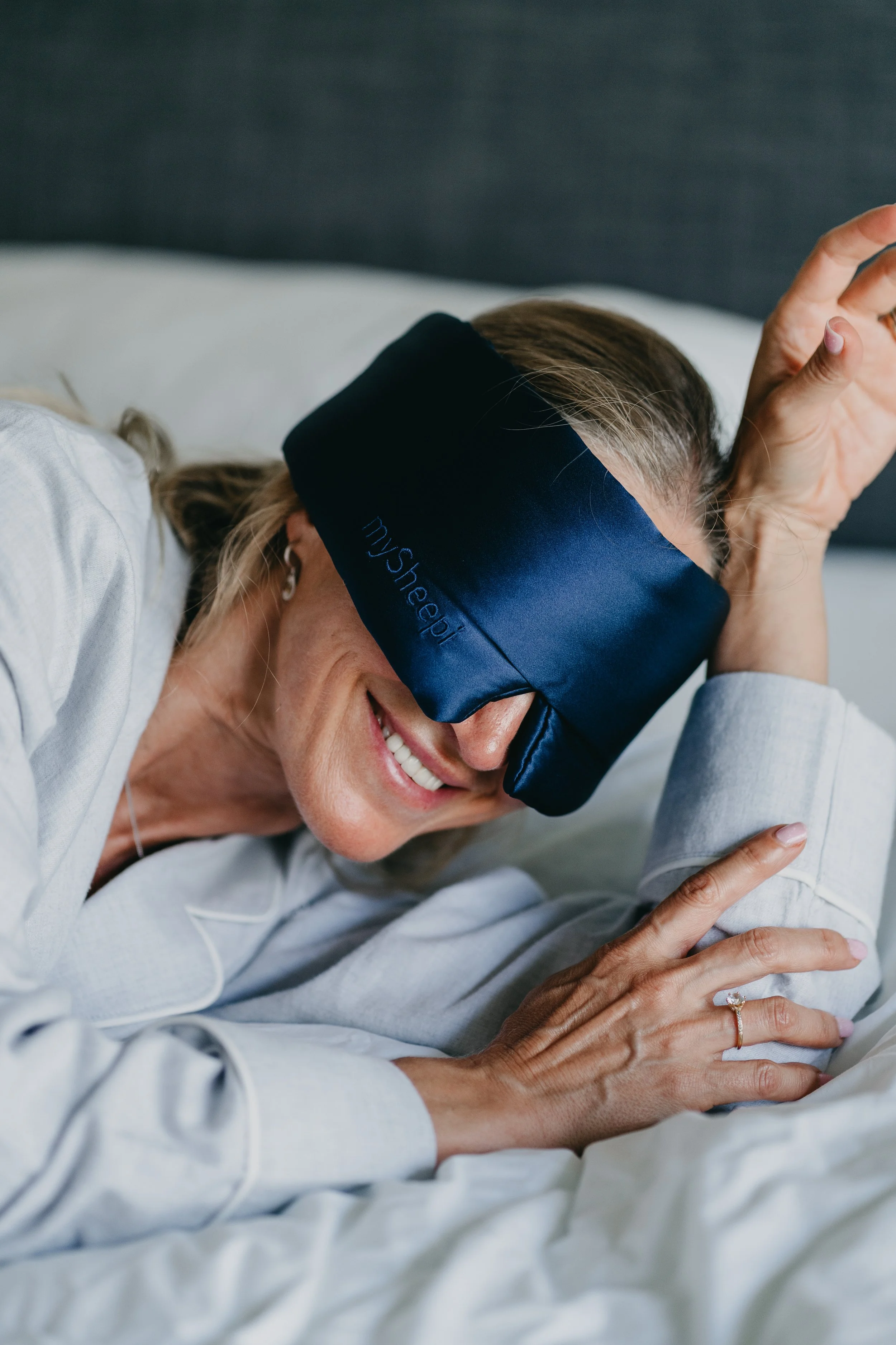 Wellness brand photography featuring a woman resting with an eye mask, expressing calm, comfort, and self-care.