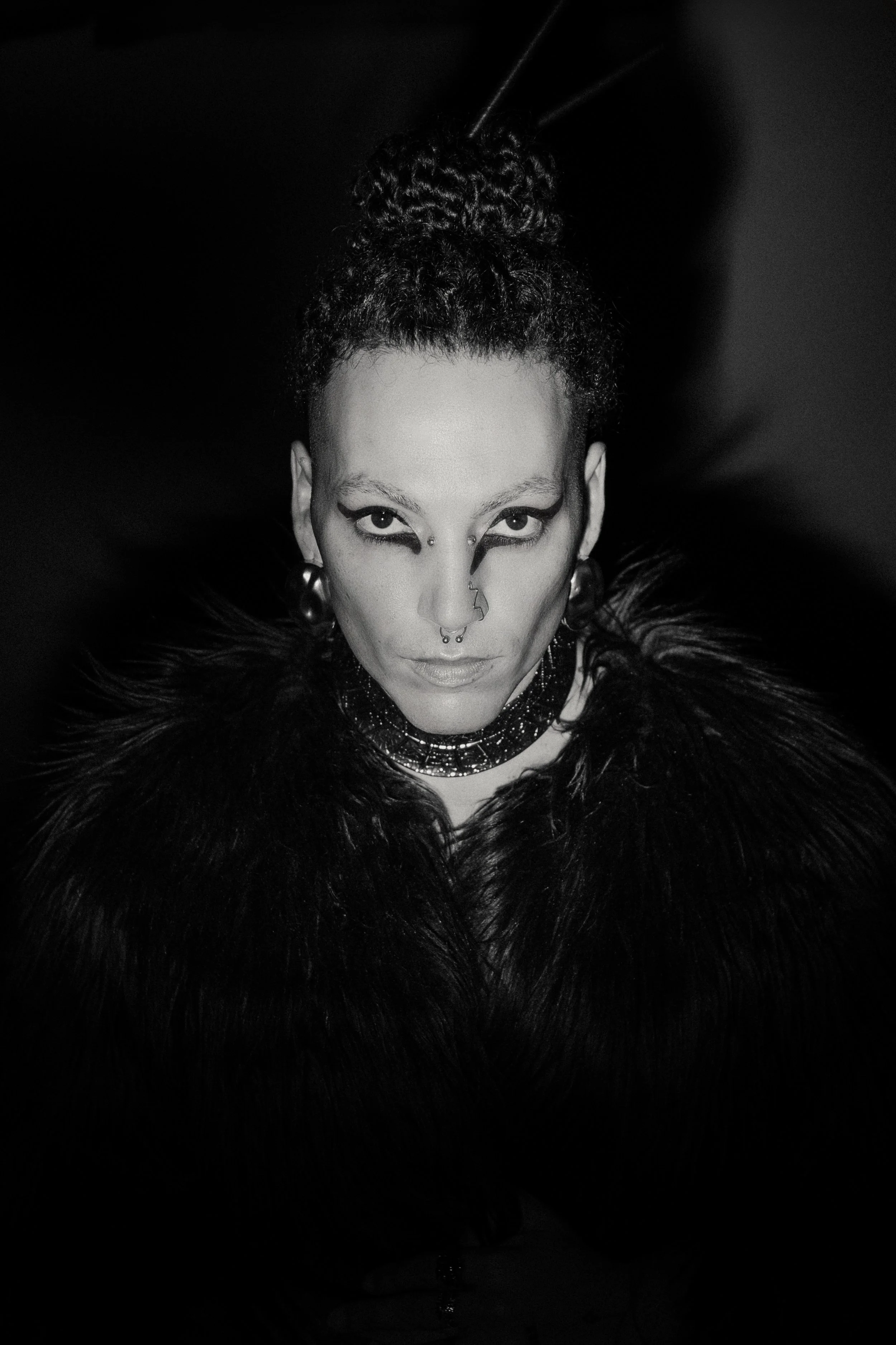 Black and white fashion portrait emphasizing contrast, texture, and emotional intensity.