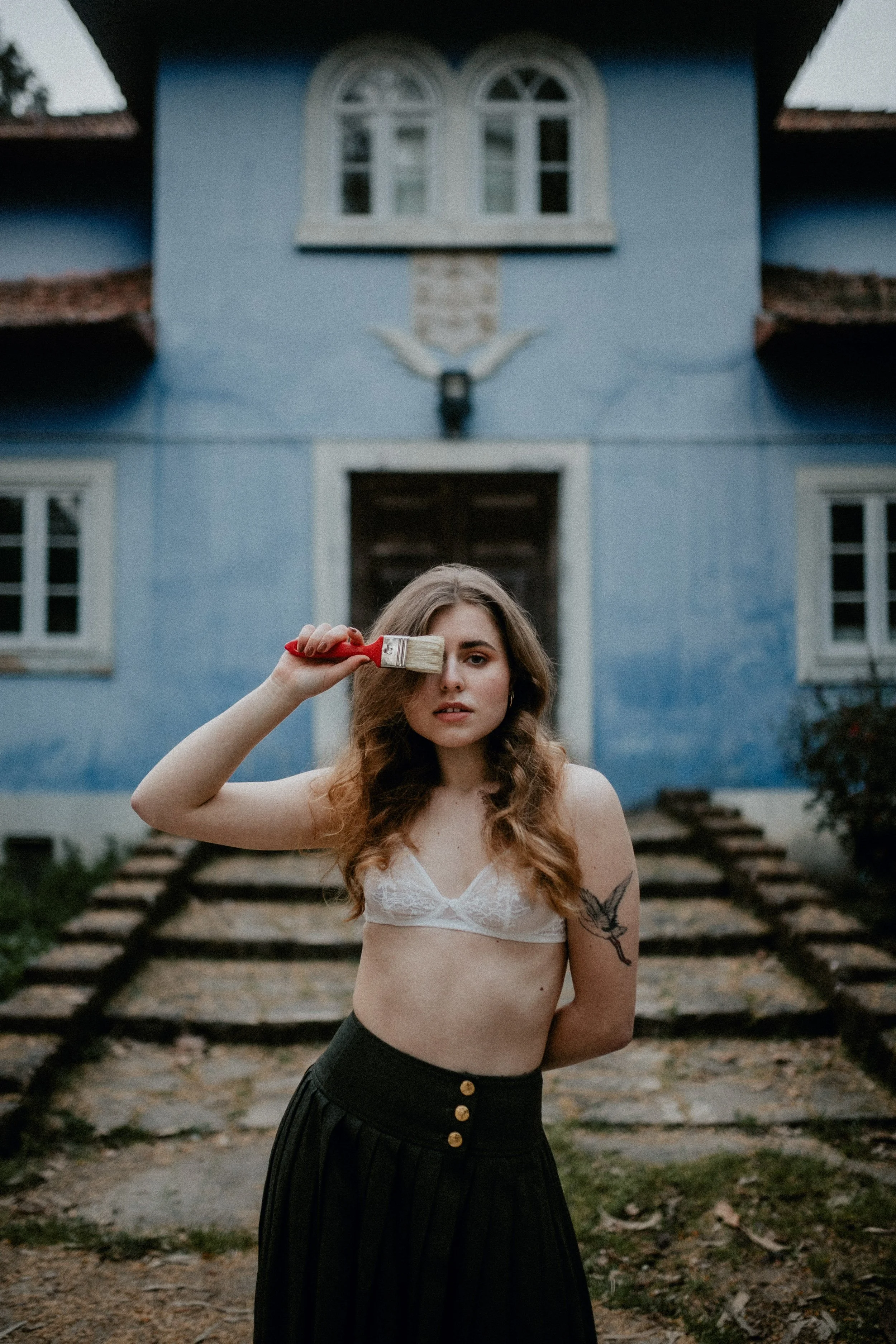 Model posing in a blue house