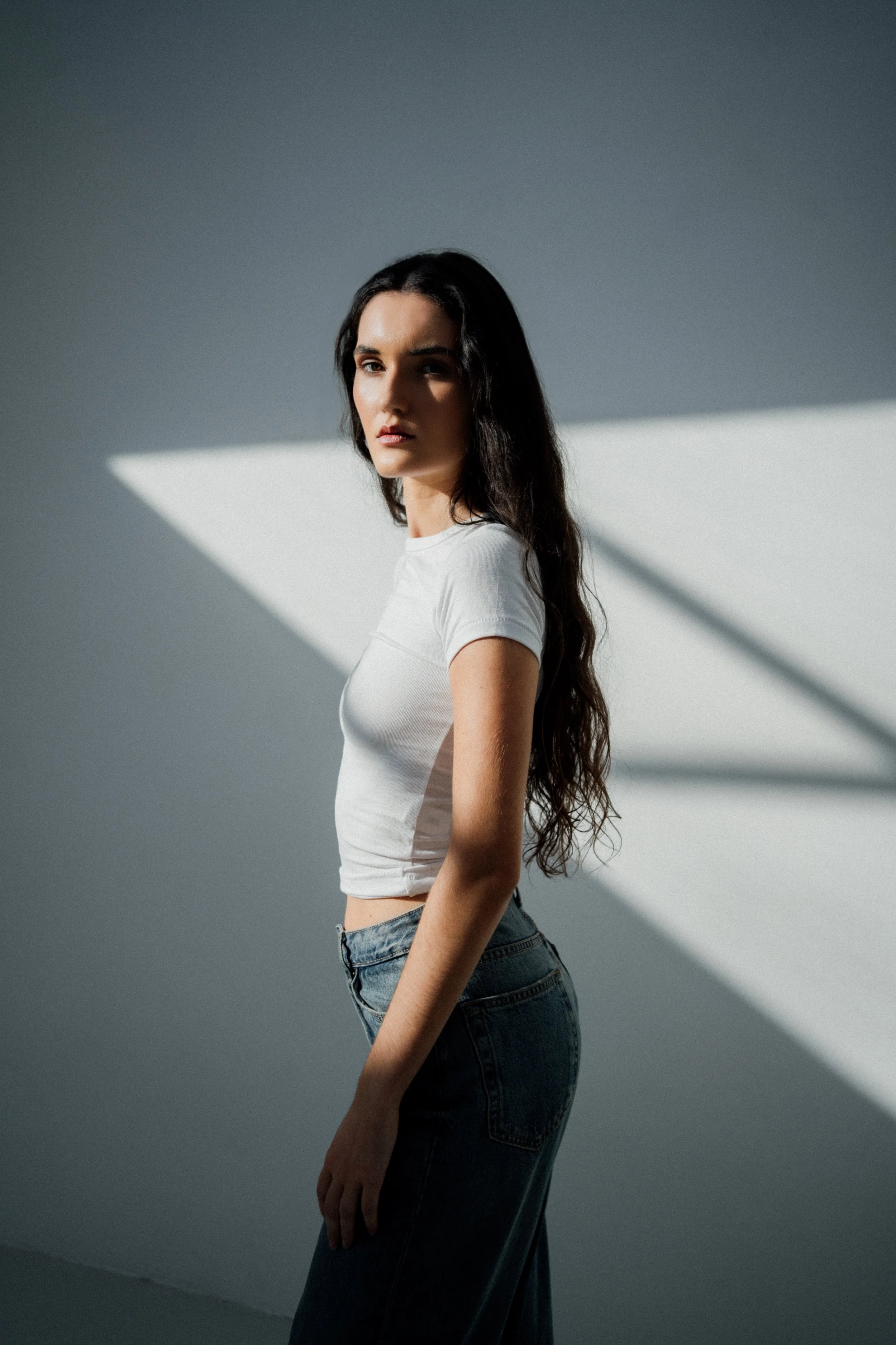 Minimal fashion portrait with clean styling and a focus on presence, silhouette, and expression.