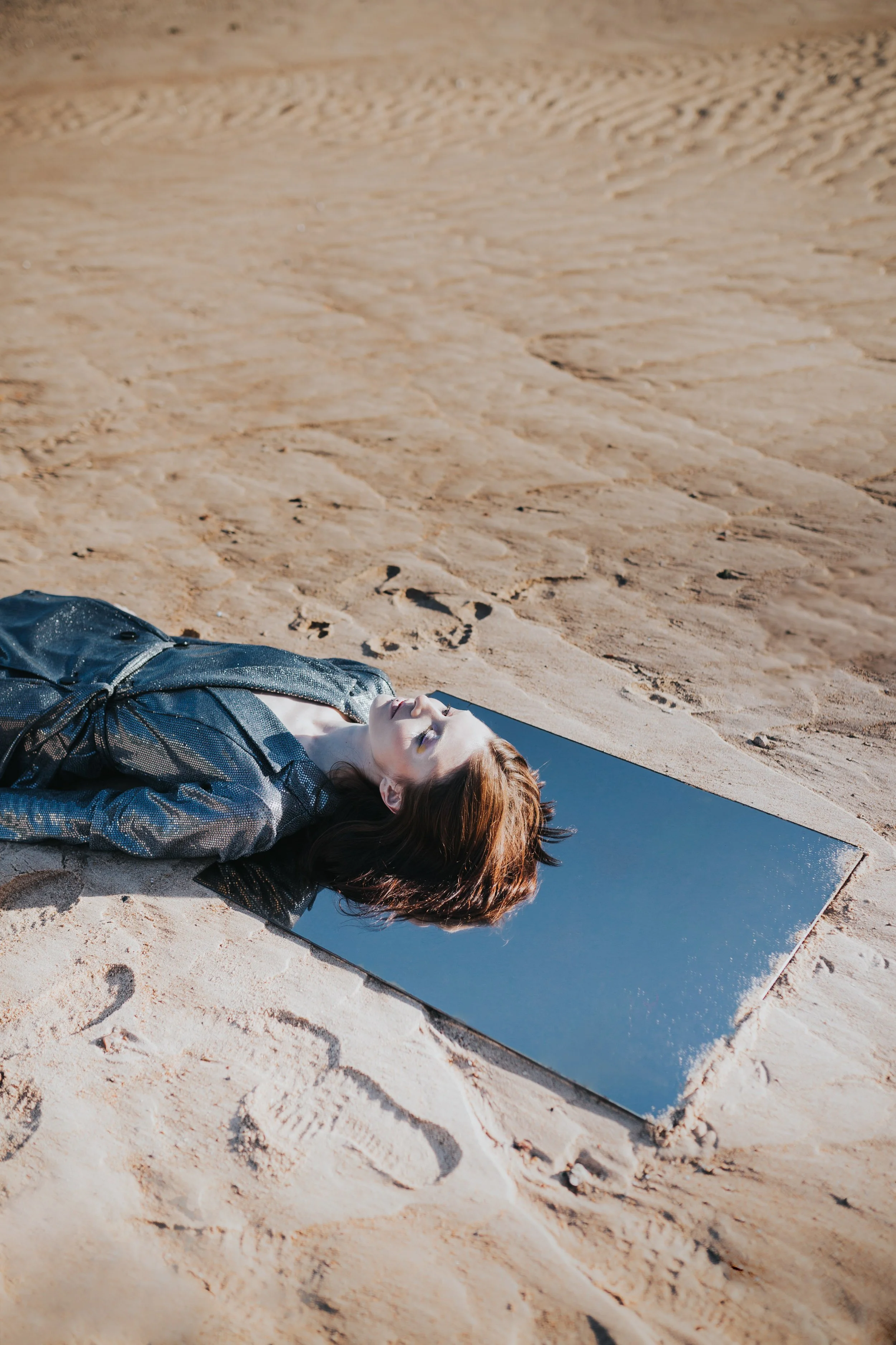 Model laying down in a mirror