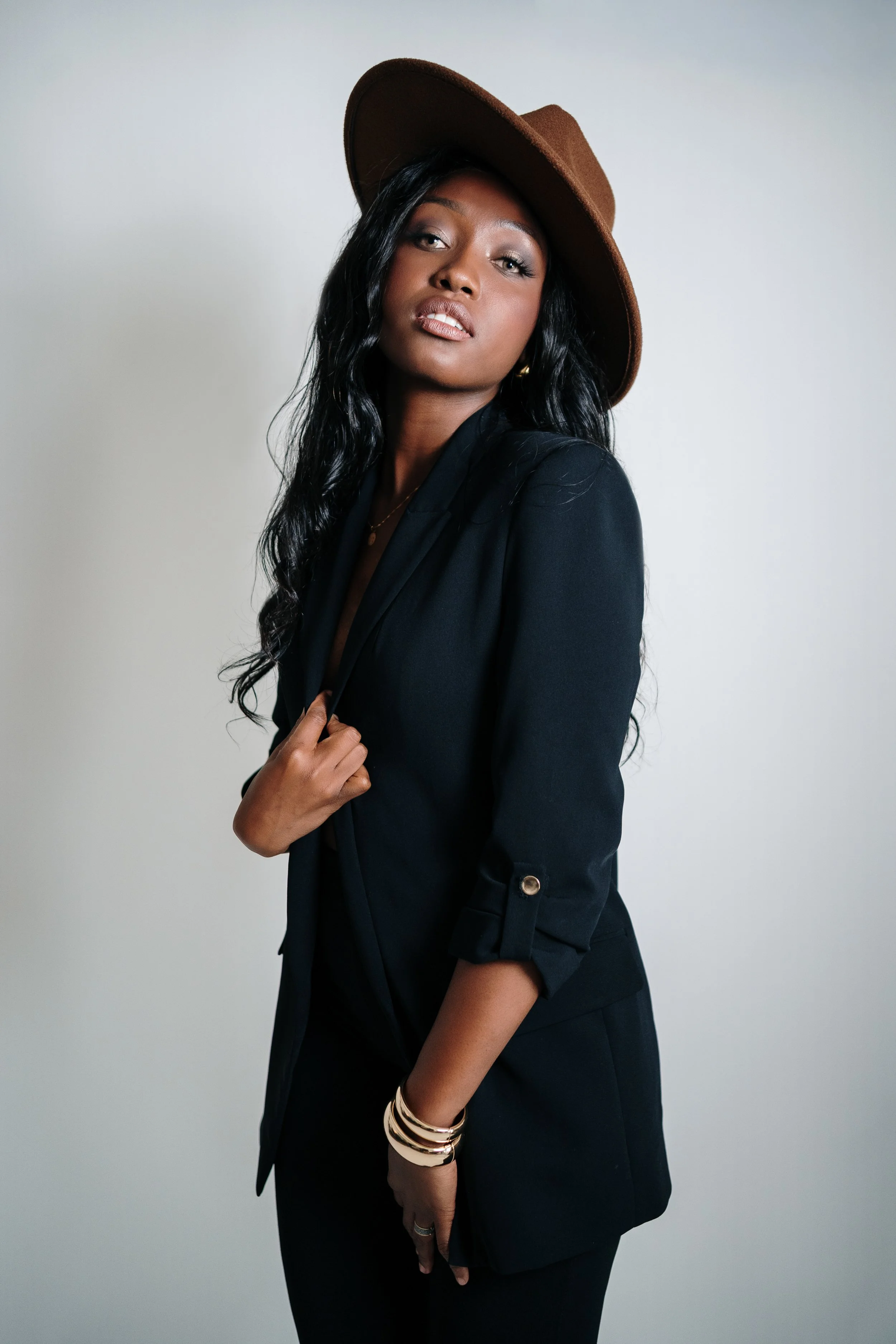 Fashion portrait of a female model photographed in studio, showcasing styling, posture, and personal attitude.