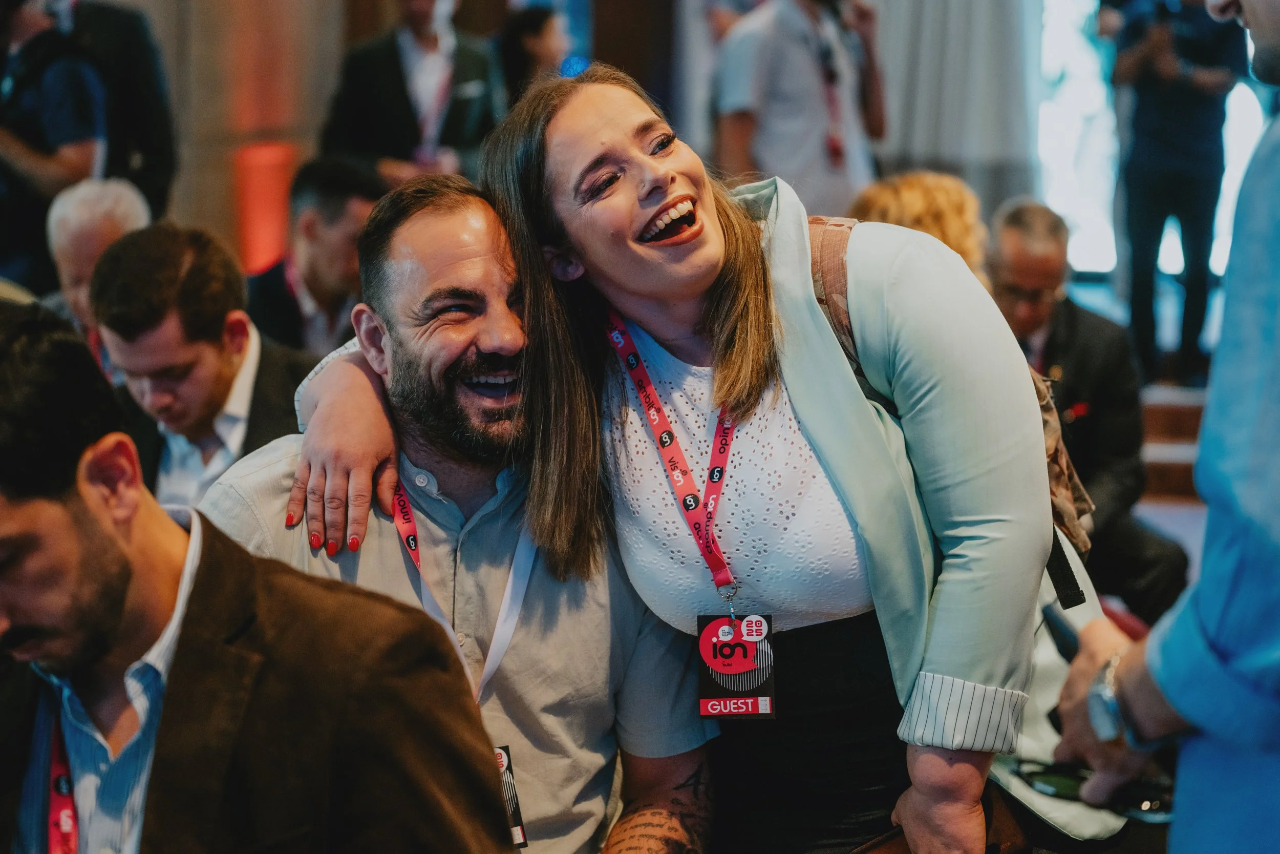 Event photography capturing natural networking moments between attendees during a professional event.